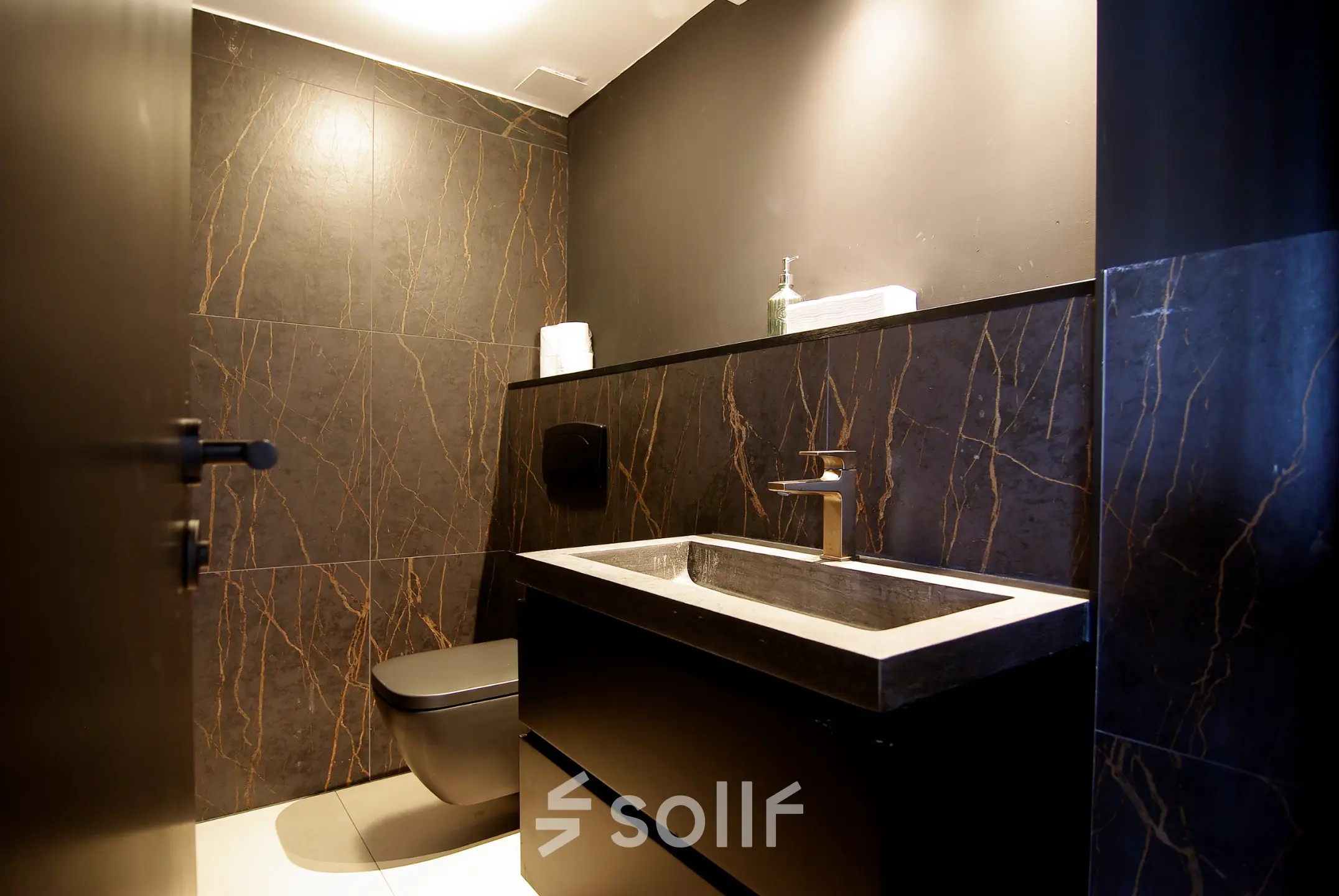 Modern office restroom at Kleine Gartmanplantsoen 21 in Amsterdam Center, featuring sleek dark tiling and contemporary fixtures. Ideal for office space rental.