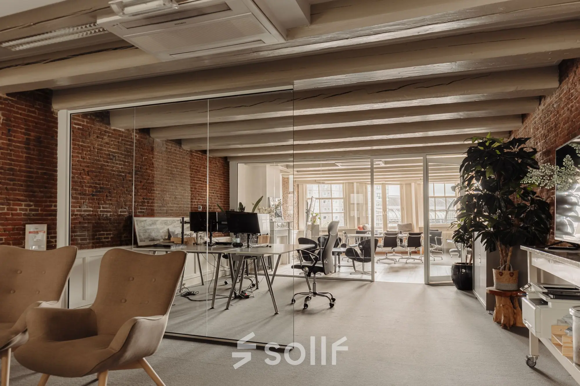 Stylish office space at Prins Hendrikkade 14, Amsterdam Center, featuring exposed brick walls, modern furnishings, and natural light. Ideal for office space rental.