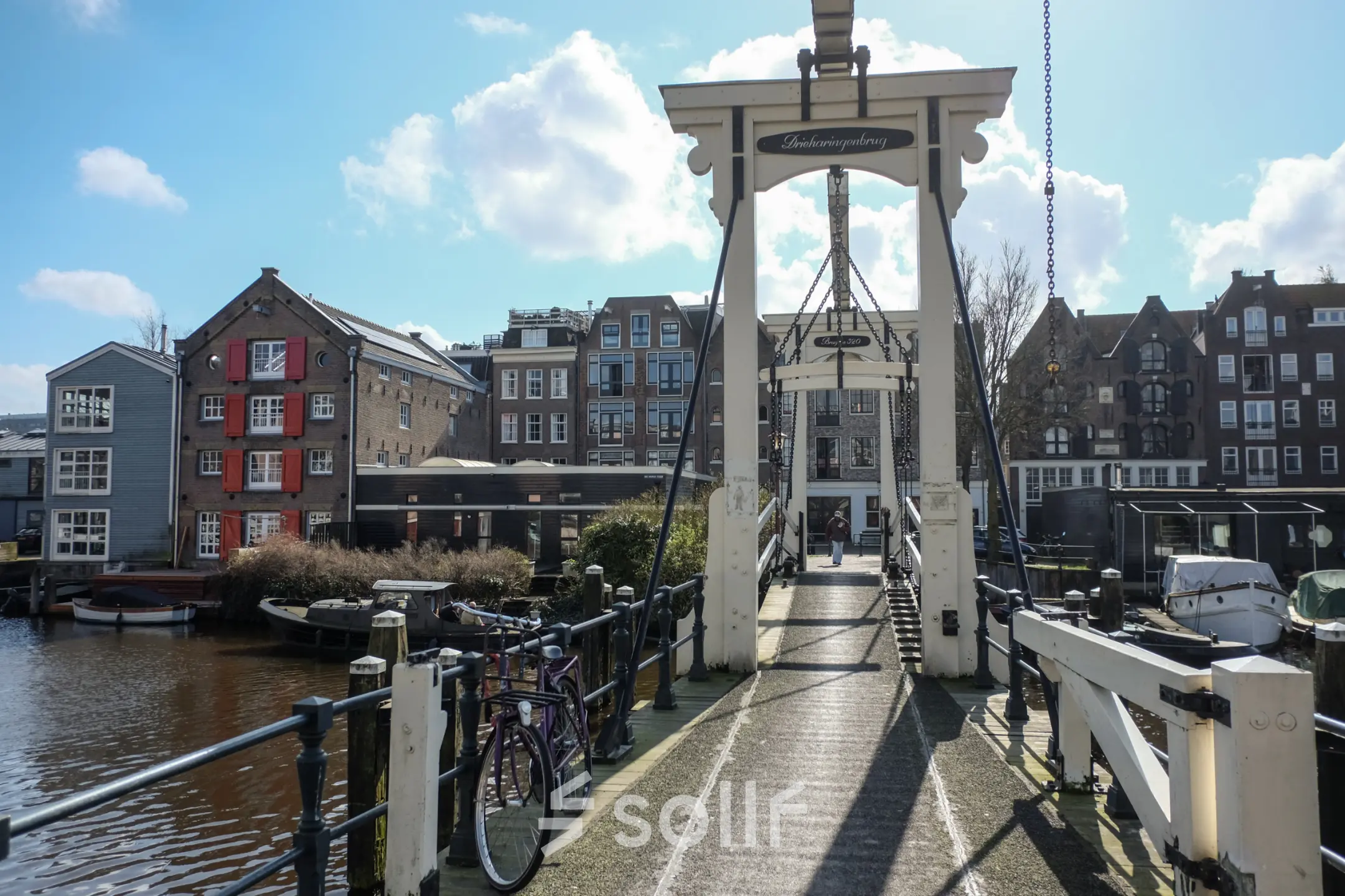 Scenic view of a bridge near office space rental at Prinseneiland 23A, Amsterdam Center with surrounding traditional buildings and a bicycle parked nearby.