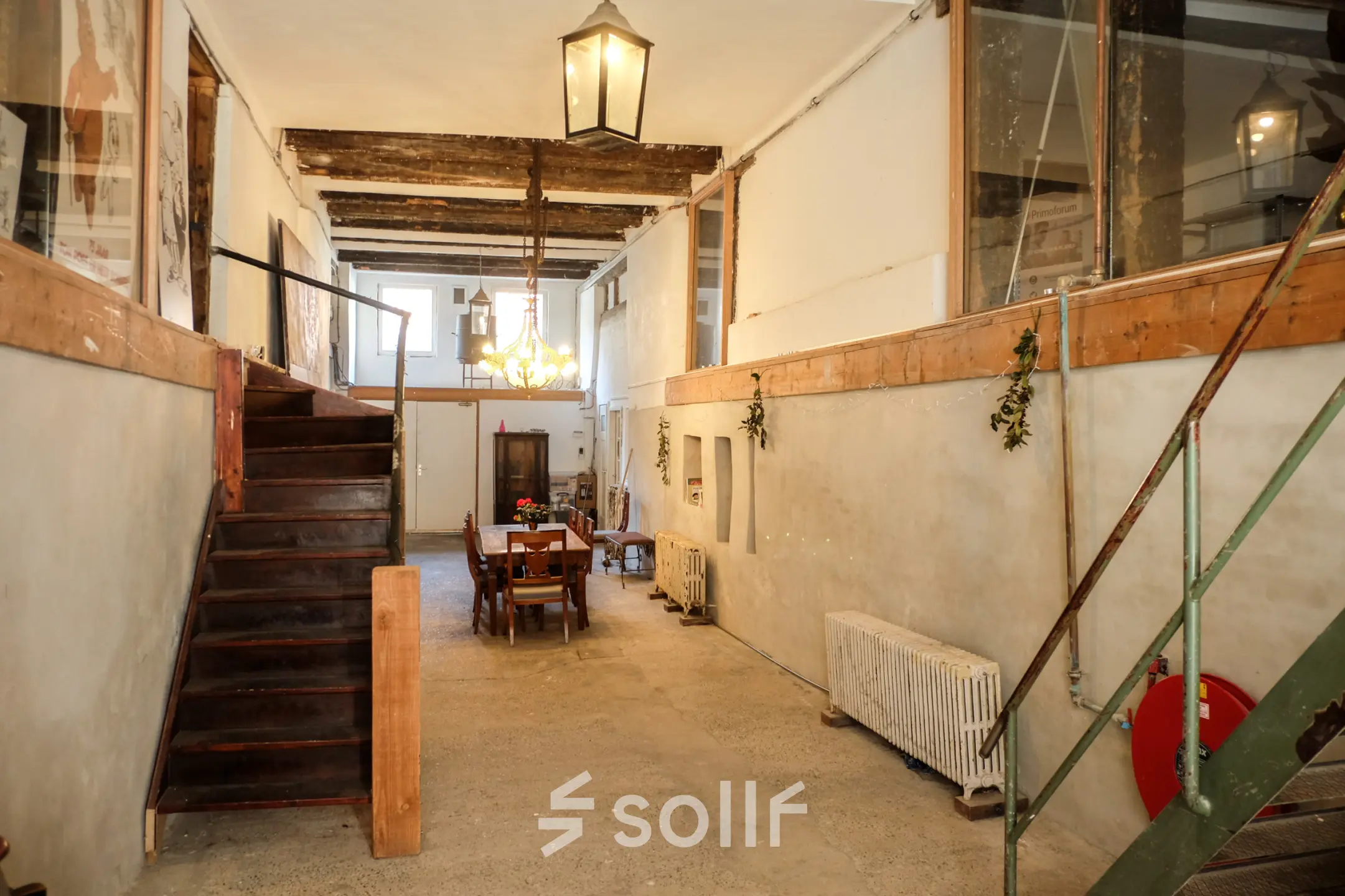 Interior view of a rustic office space at Prinseneiland 23A, with a wooden table and chairs under warm lighting, available for rent in Amsterdam Center.