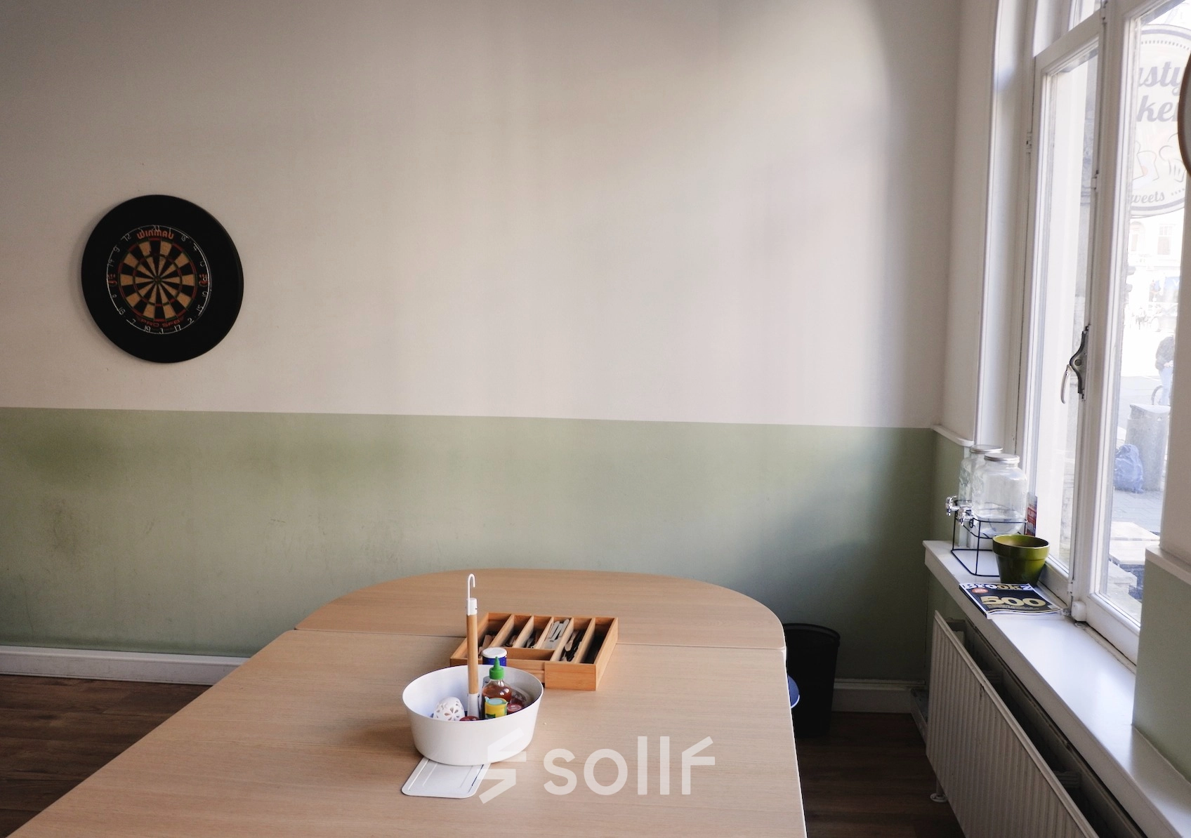 Office space rental in Raadhuisstraat 15, Amsterdam Center featuring a table with office supplies and a dartboard on the wall.