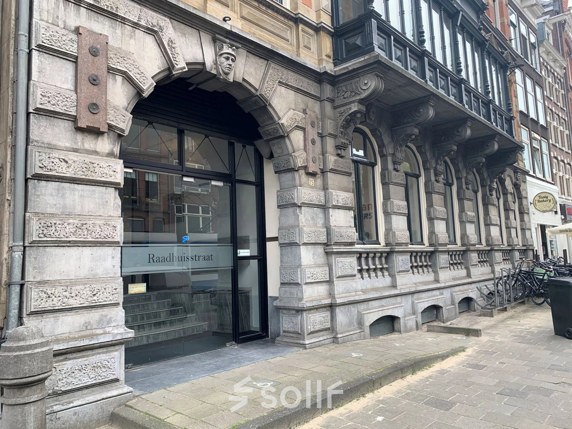 Exterior view of office space for rent at Raadhuisstraat 15, Amsterdam Center, showcasing a historic stone facade.