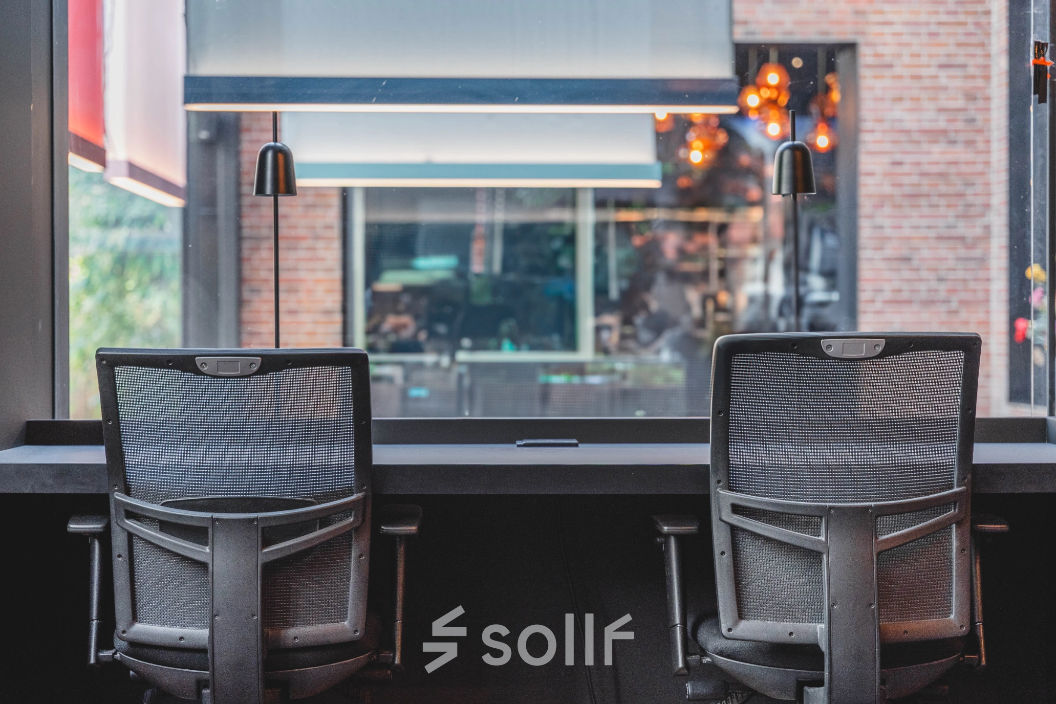 Modern office space at Raamplein 1, Amsterdam Center, featuring furnished workspaces ideal for office space rental with two ergonomic chairs and a large window view.