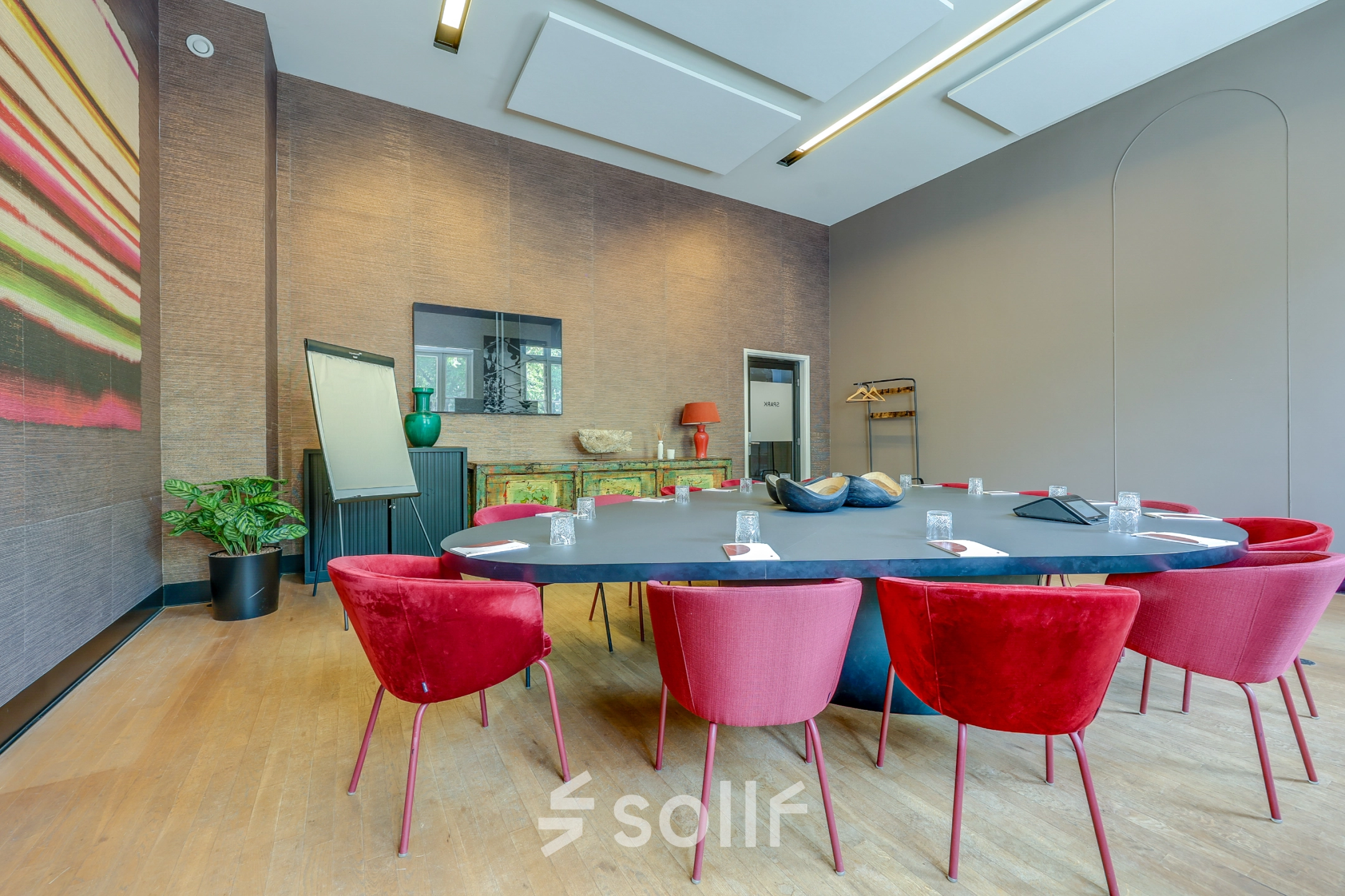 Modern conference room at Raamplein 1, Amsterdam Center, featuring a large oval table with red chairs, available for office space rental.
