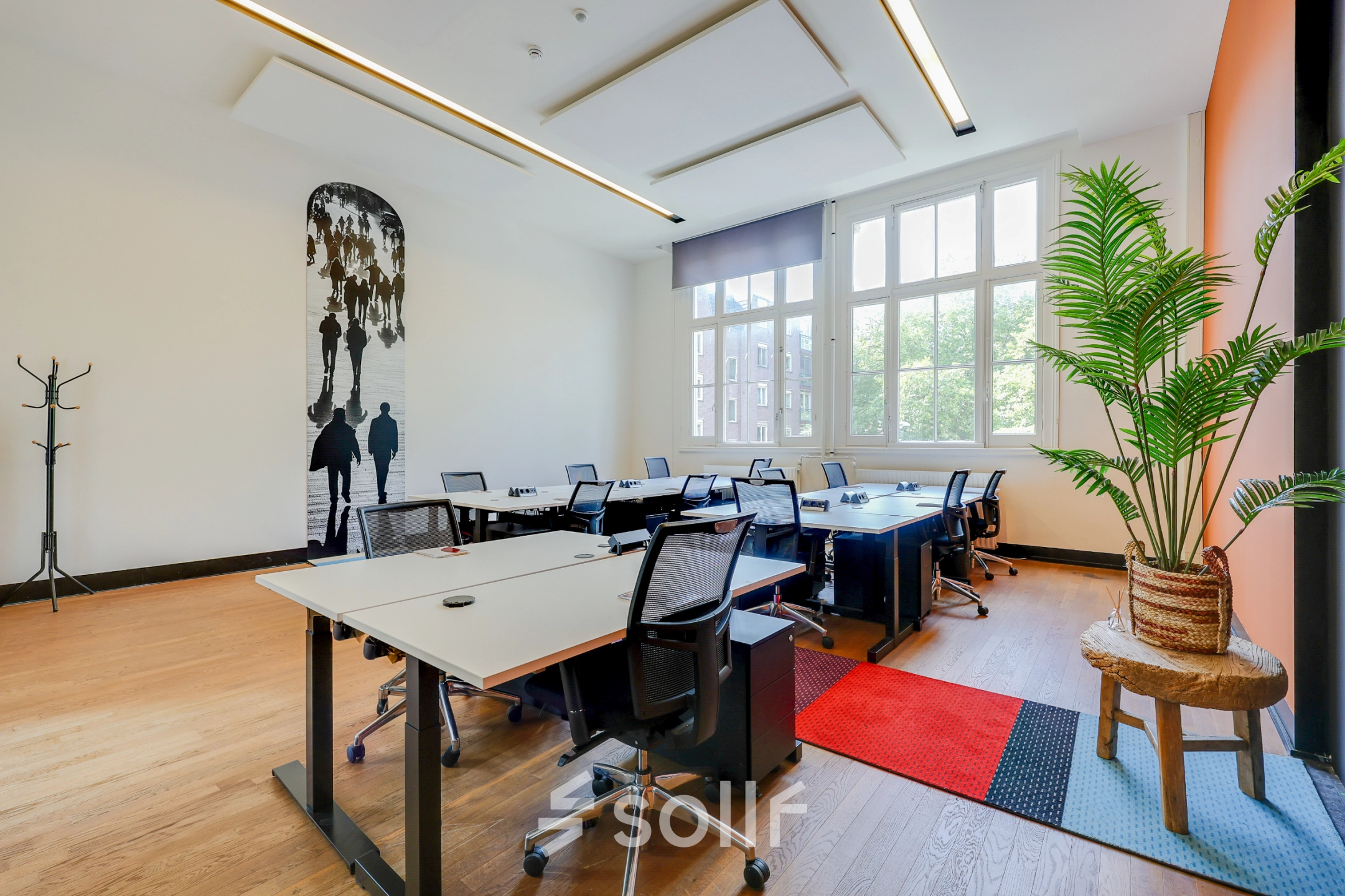 Bright office space for rent at Raamplein 1, Amsterdam Center. The furnished room features multiple desks and chairs, suitable for a collaborative work environment.