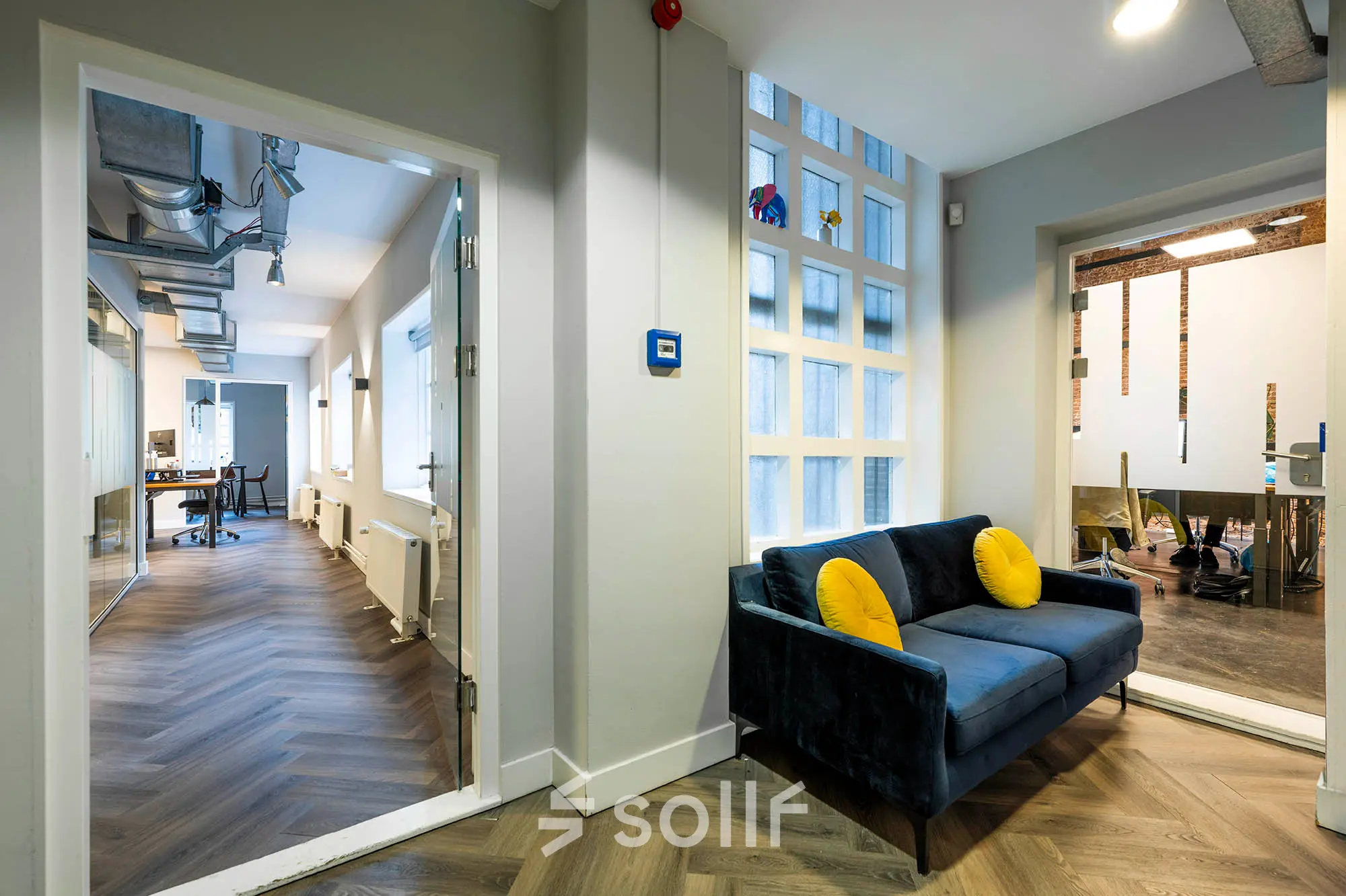 Modern office space at Rapenburgerstraat 173 in Amsterdam Center, featuring a cozy lounge area and workspace setup for rent.