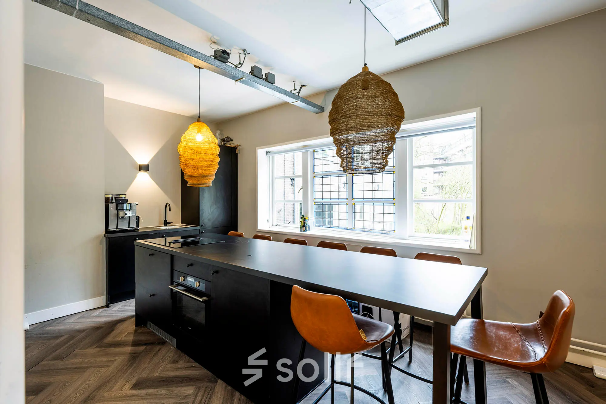 Modern office kitchen area with a central island and seating at Rapenburgerstraat 173, ideal for rent office space in Amsterdam Center.