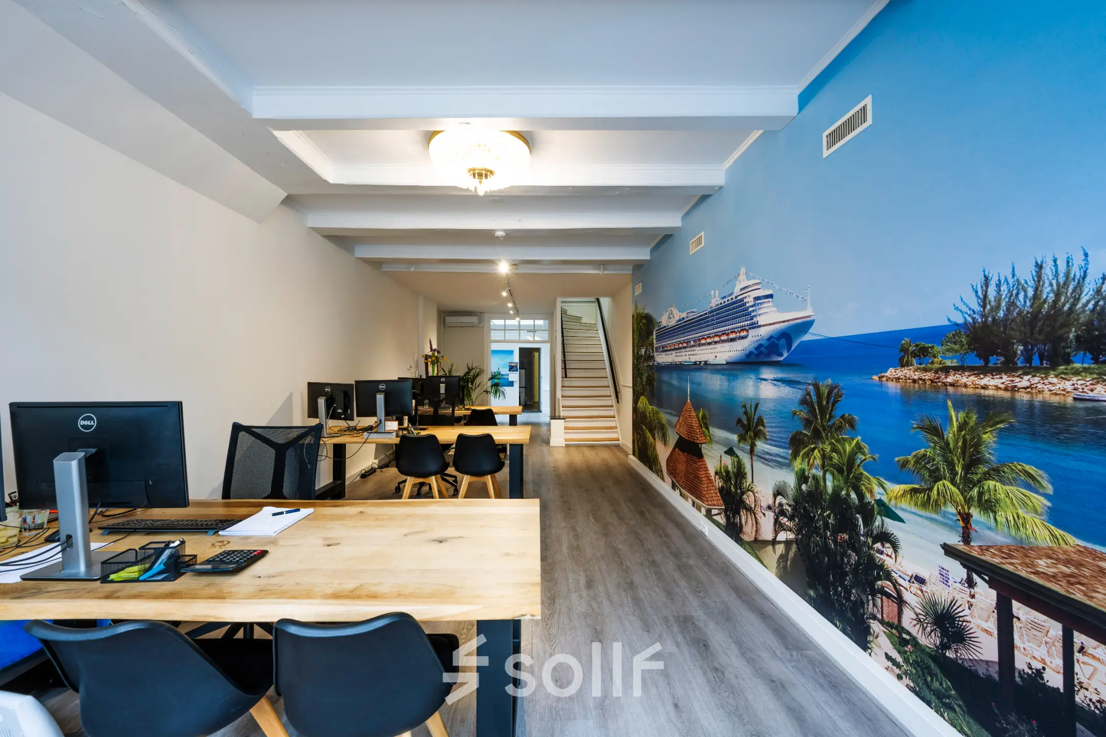 Bright office space rental at Rokin 105 105 in Amsterdam Center featuring desks, chairs, and a tropical mural, ideal to rent office space.