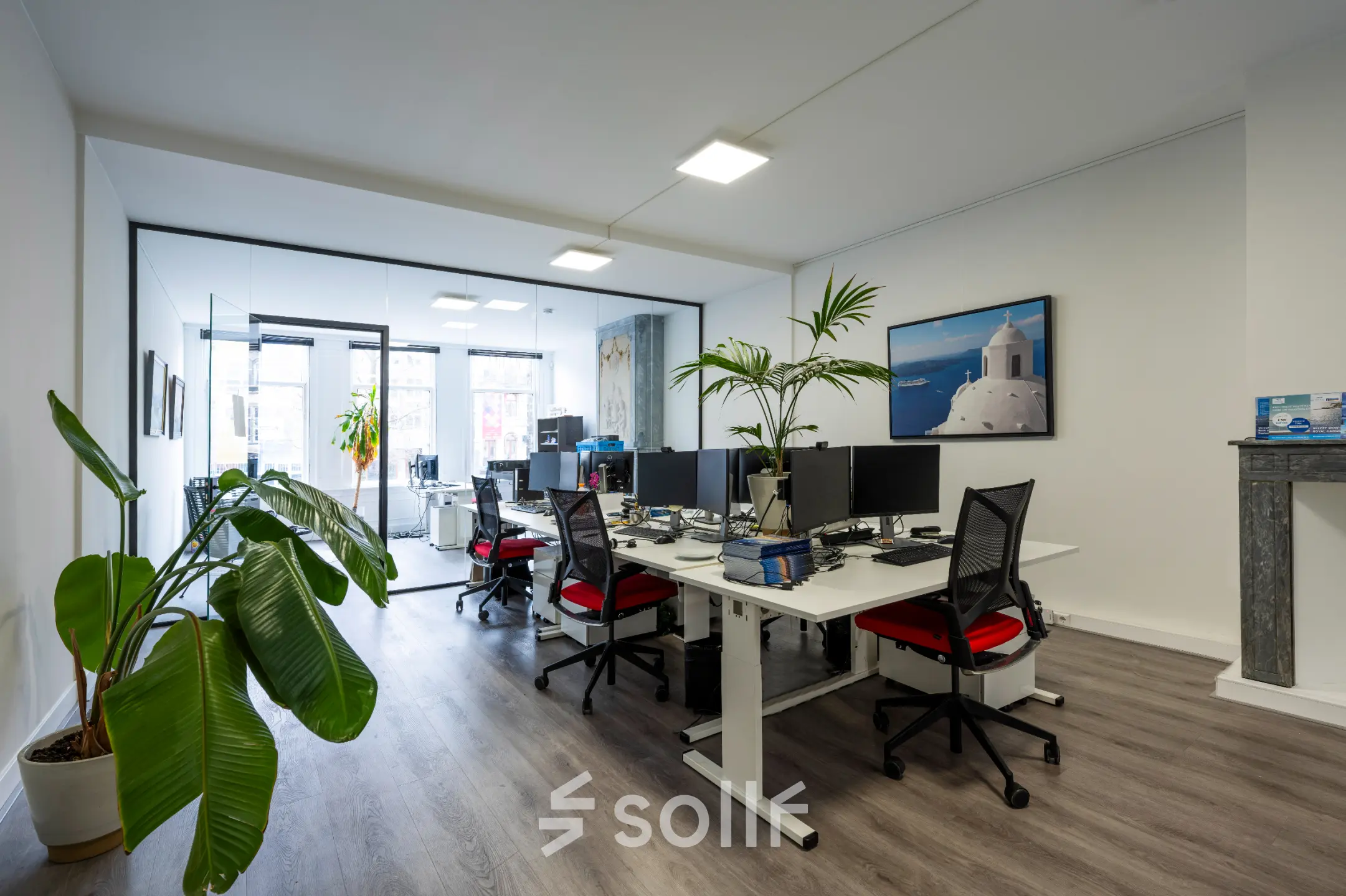 Modern office to rent at Rokin 105 105, Amsterdam Center, featuring a sleek open floorplan with multiple workstations, computers, and greenery.