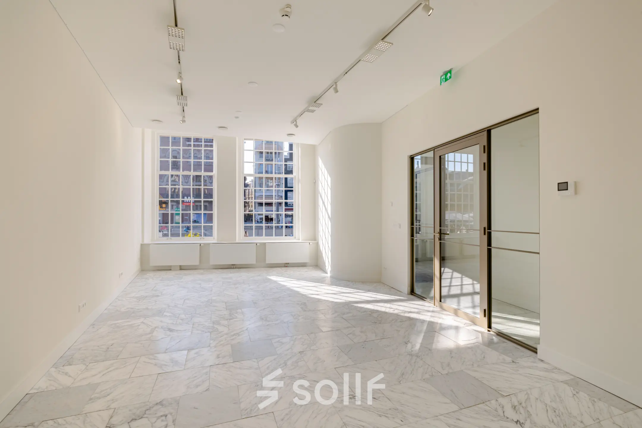 Bright office space at Rokin 117, Amsterdam Center, featuring marble floors and large windows ideal for office space rental.