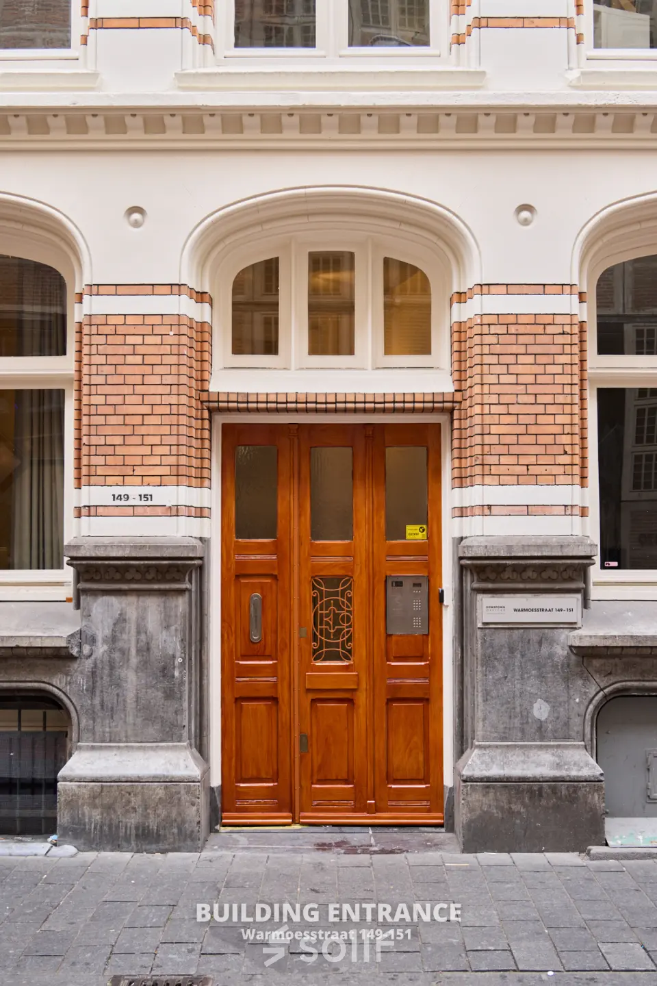 Elegant exterior view of an office building entrance at Warmoesstraat 149-151, perfect for those seeking office space rental in Amsterdam Center.