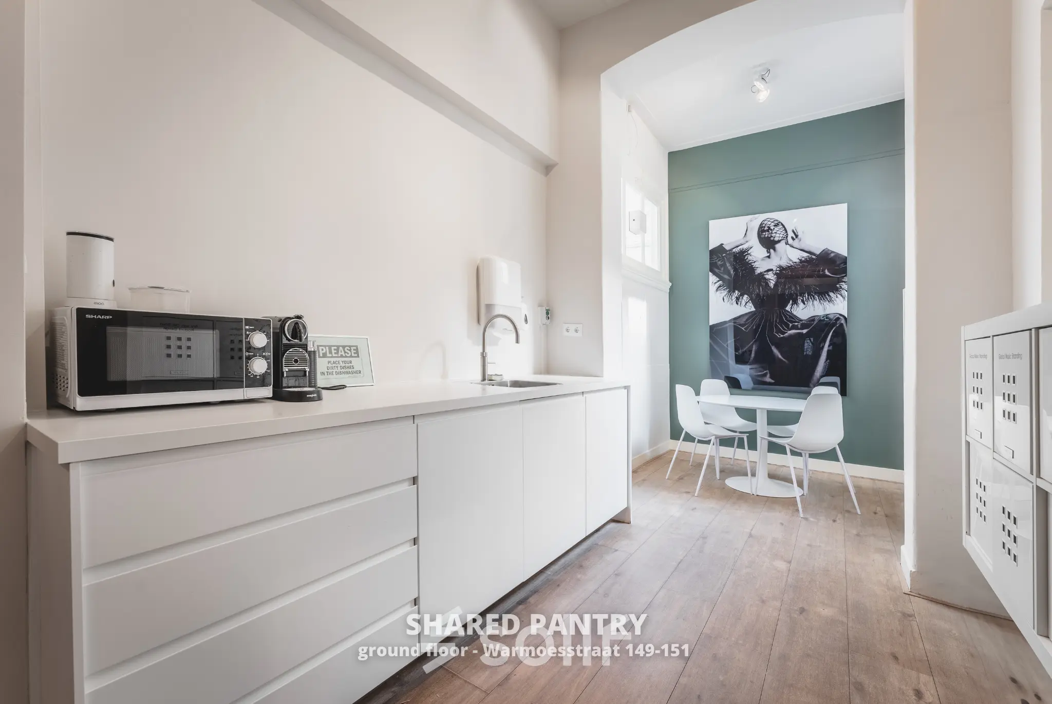 Shared pantry area at Warmoesstraat 149-151, Amsterdam Center, ideal for office space rental, with modern appliances and a cozy seating area for breaks.