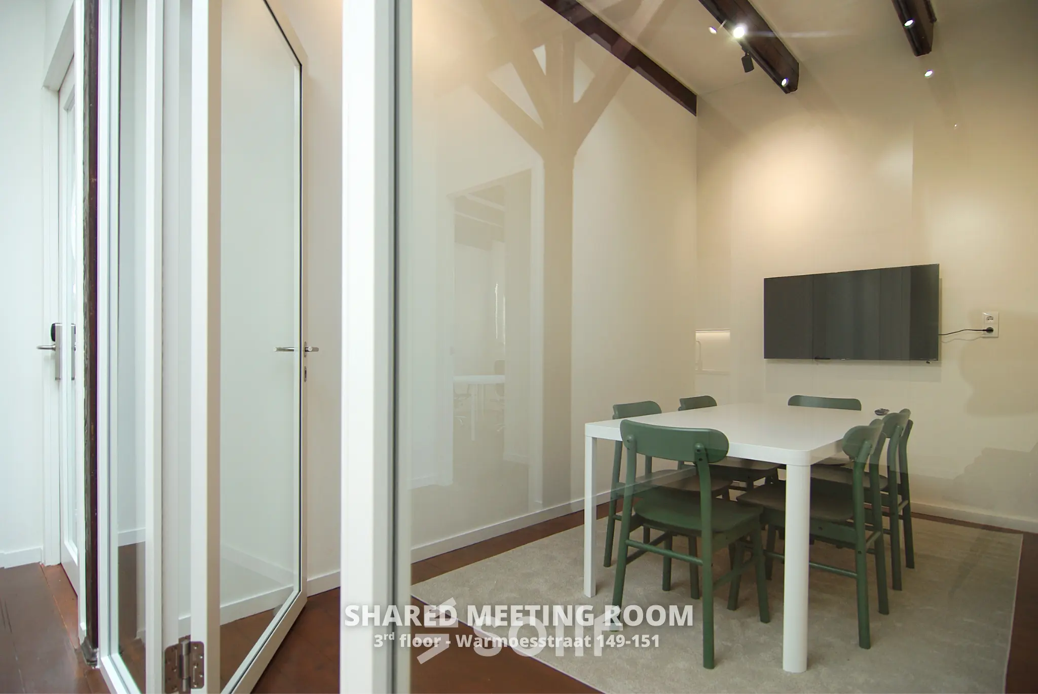 Modern furnished conference room at Warmoesstraat 155, Amsterdam Center, perfect for office space rental. The room is equipped with a large table and chairs, suitable for meetings.