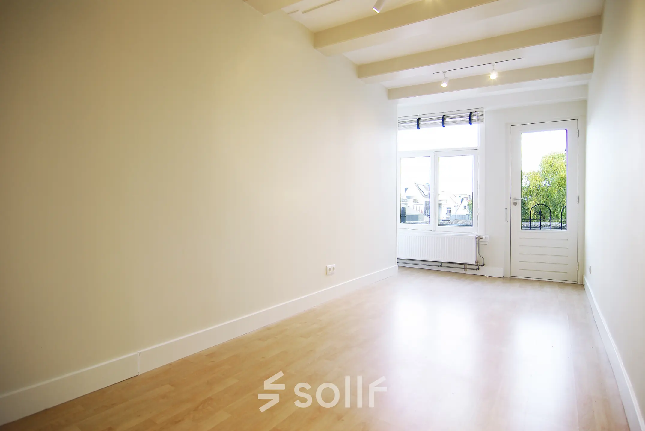 Bright and unfurnished office space for rent at Warmoesstraat 155, Amsterdam Center, featuring large windows and wooden flooring, ideal for office space rental.