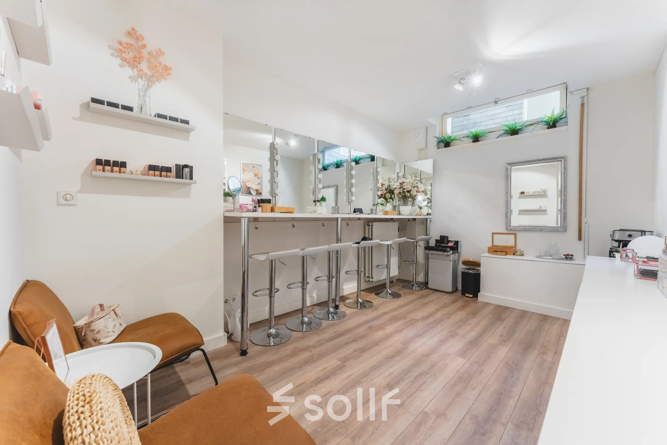 Bright and stylish office space with bar-style seating and decorative plants, located at Warmoesstraat 155, Amsterdam Center, available for rent.