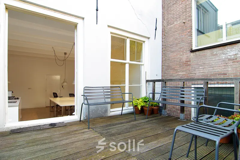 Outdoor seating area at an office to rent on Warmoesstraat 155, Amsterdam Center, with beyond view of an interior workspace.