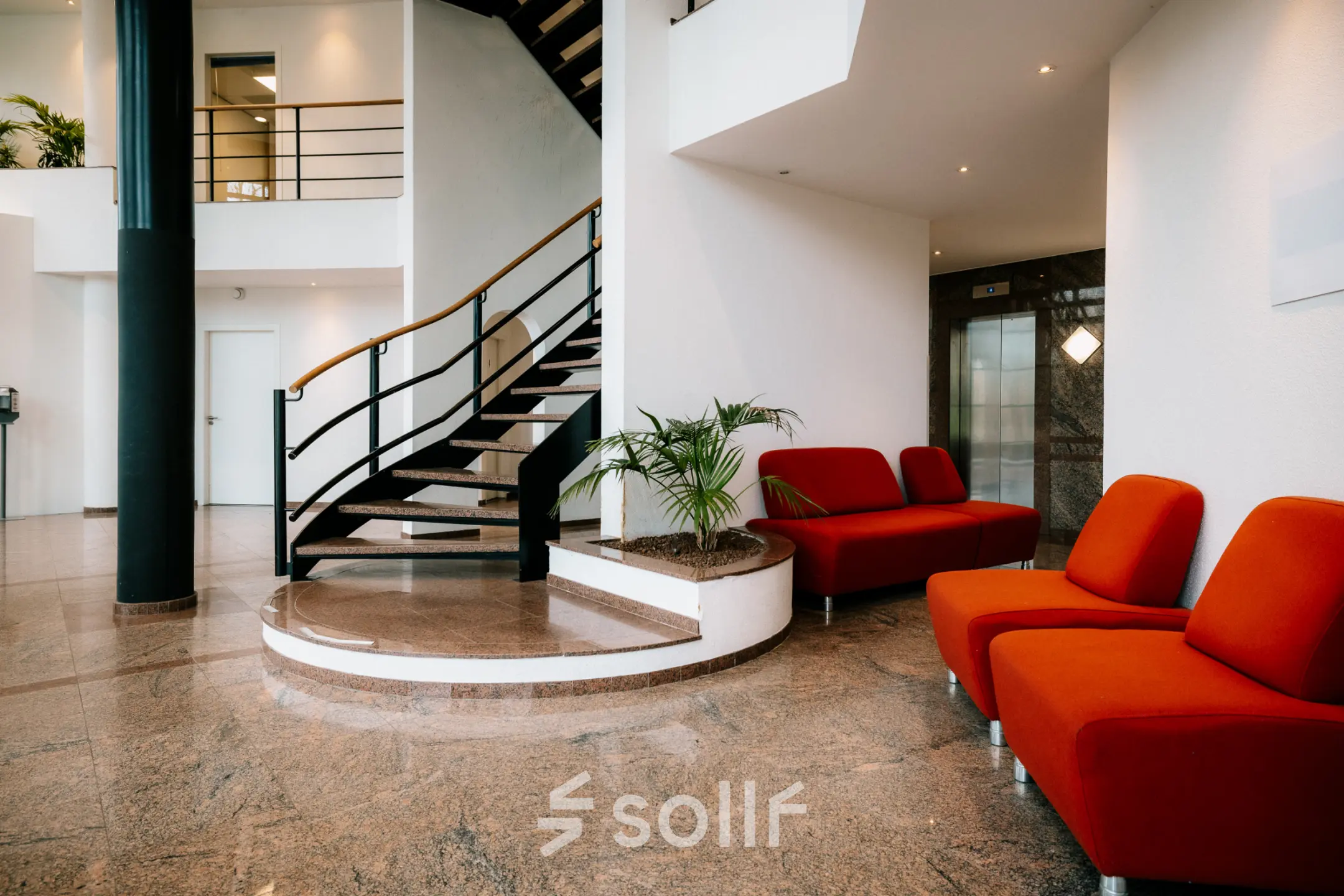 Modern office space with red seating, a spiral staircase, and a bright, welcoming atmosphere at Overschiestraat 182, Amsterdam De Schinkel. Ideal for office space rental.