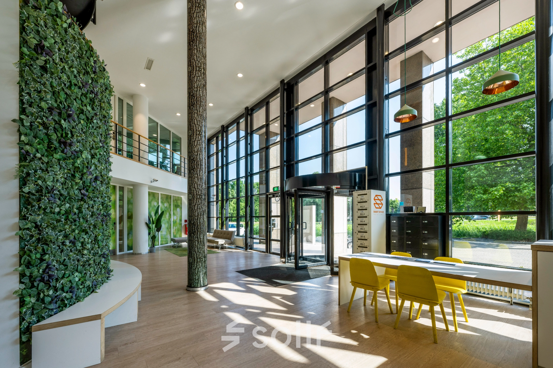 Bright, spacious office interior at Overschiestraat 186, Amsterdam De Schinkel, featuring large windows, modern furniture, and lush greenery. Great option for office space rental.