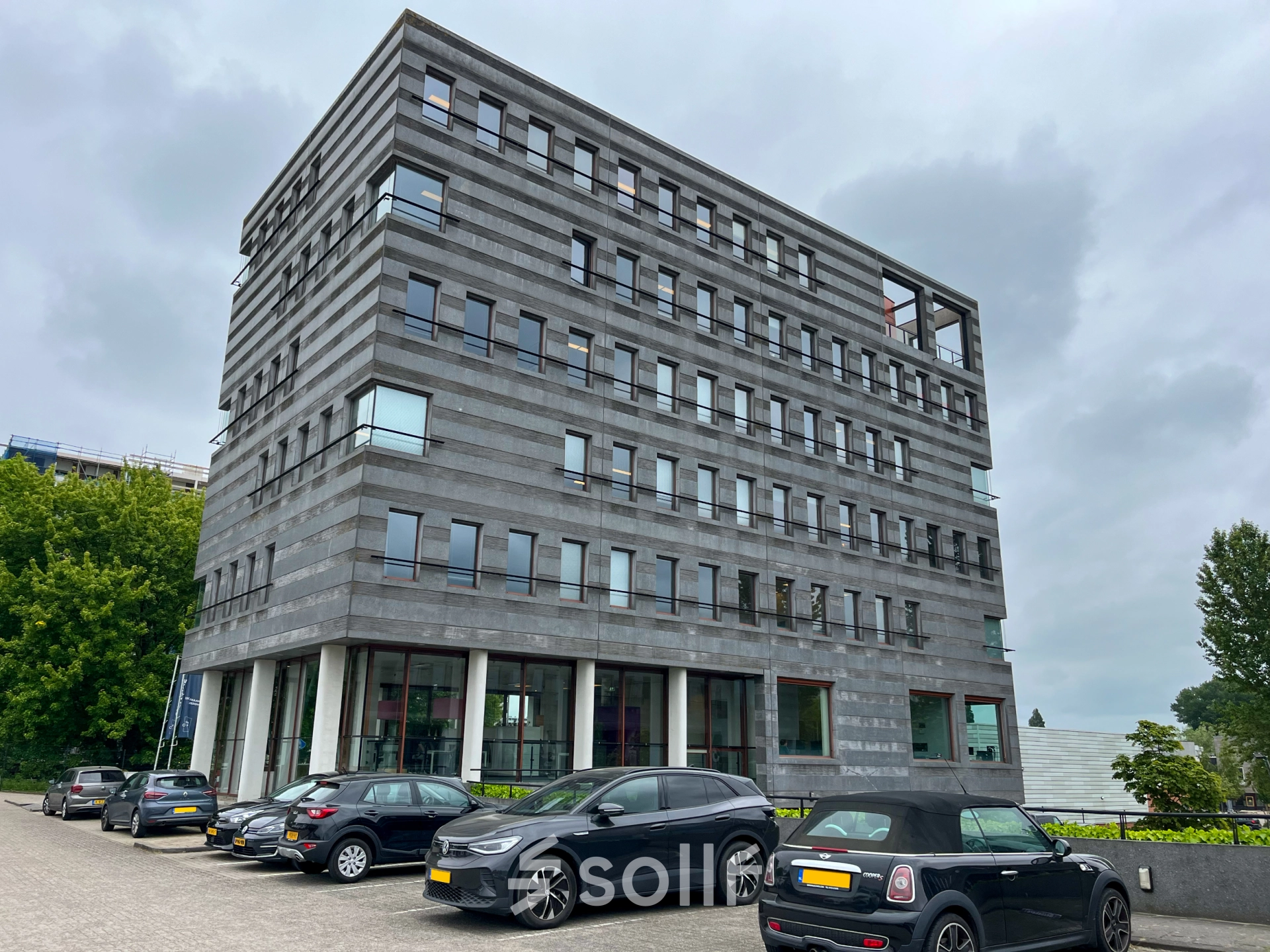 Exterior view of the office building at Daalwijkdreef 47, Amsterdam Duivendrecht, featuring multiple floors and parking area, ideal for office space rental.