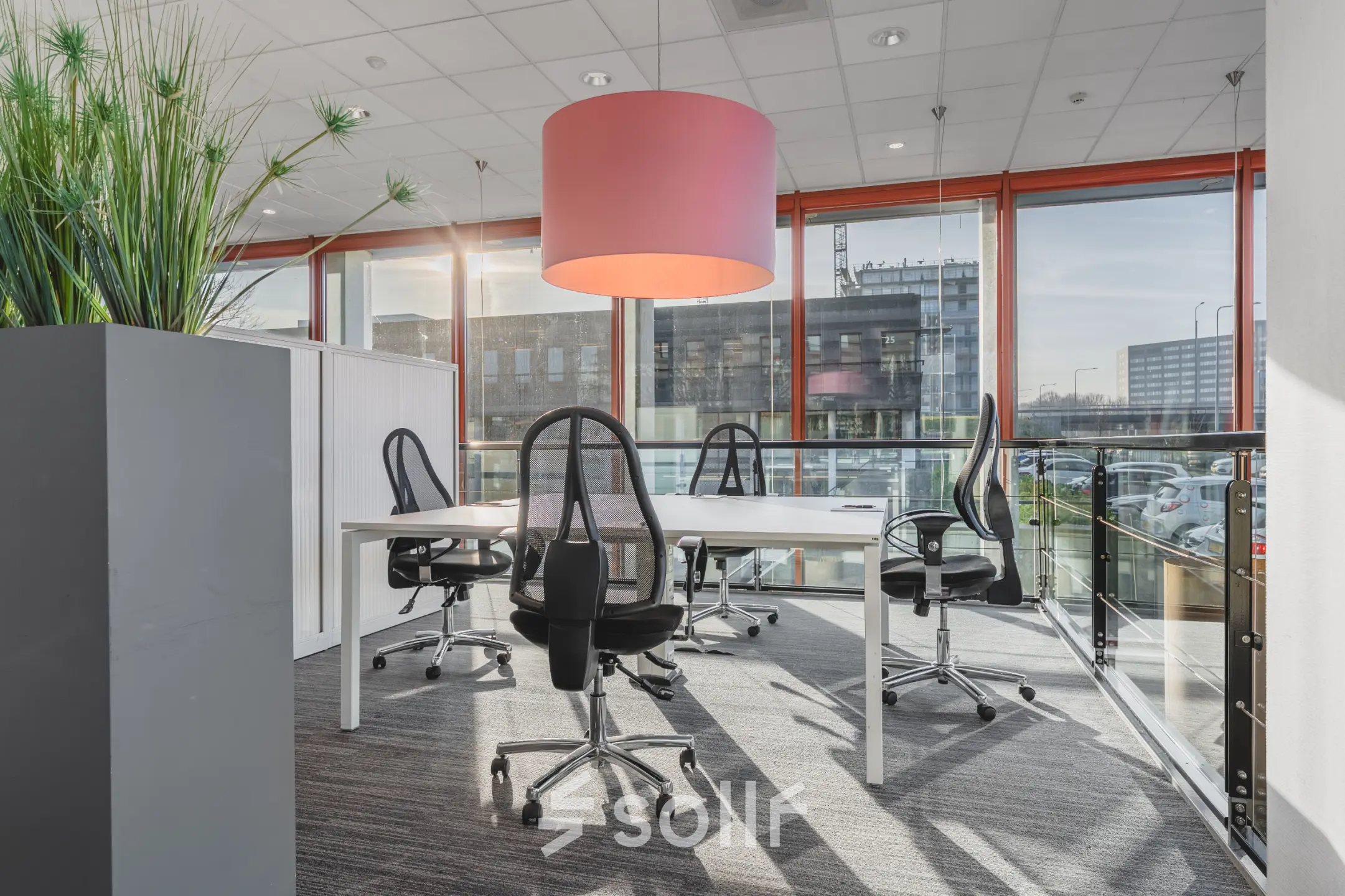 Bright office to rent in Amsterdam Duivendrecht with modern furniture and large windows offering a city view.