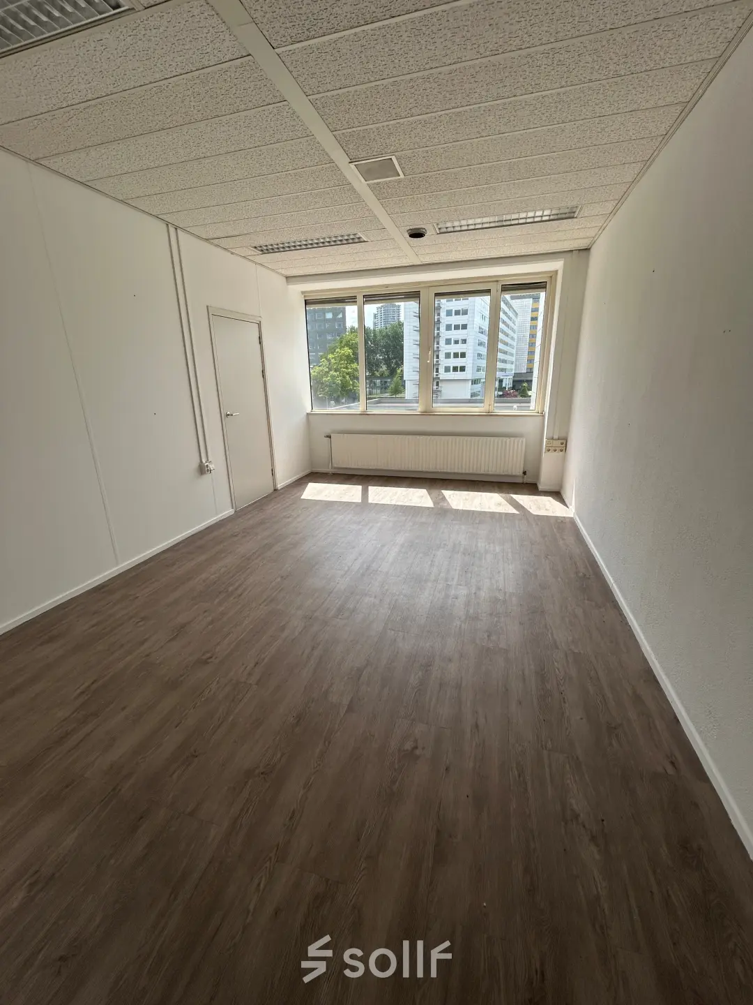 Unfurnished office space with large windows at James Wattstraat 71, Amsterdam East, available for rent. Ideal for businesses seeking an open floorplan.
