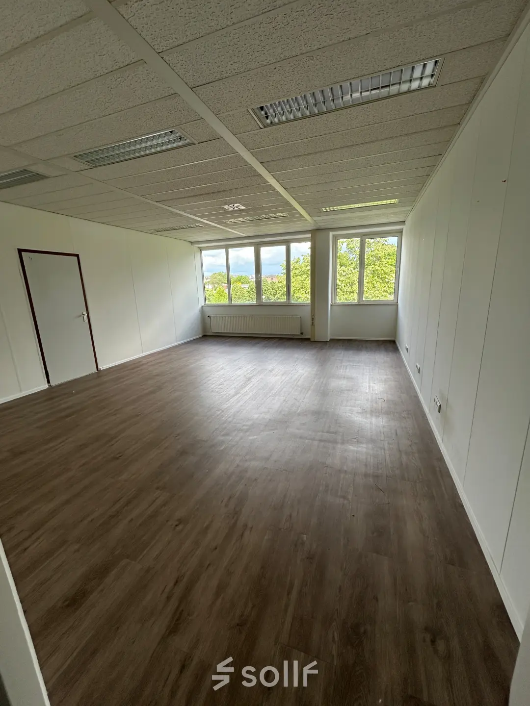 Spacious, unfurnished office at James Wattstraat 71, Amsterdam East, with large windows and ample natural light, ideal for office space rental.