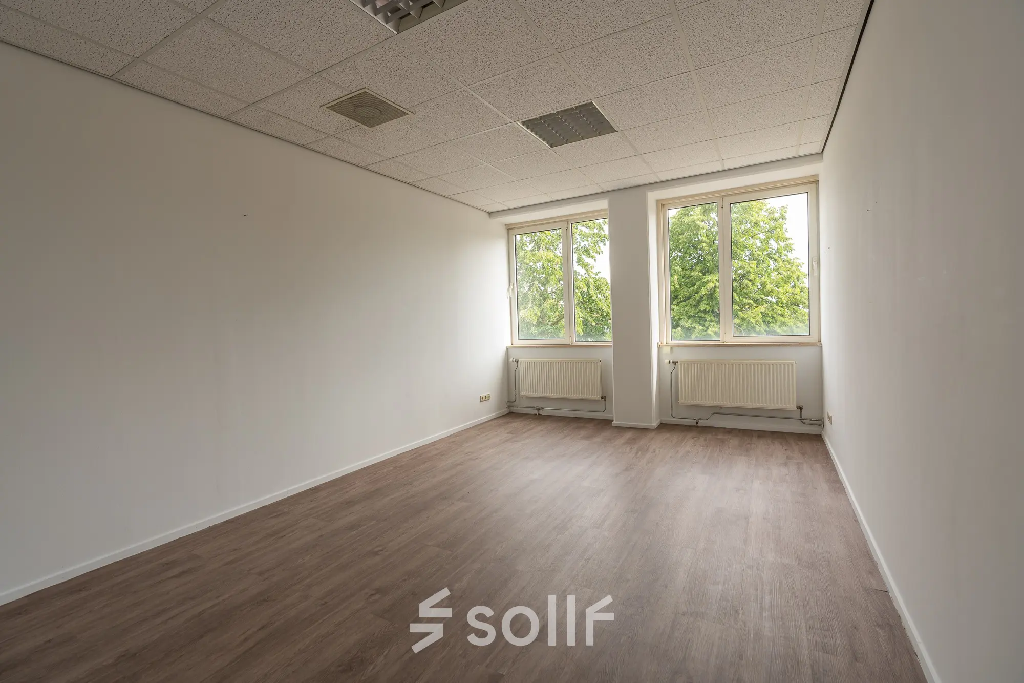 Bright office space for rent at James Wattstraat 71, Amsterdam East, featuring large windows with ample natural light and wood flooring.