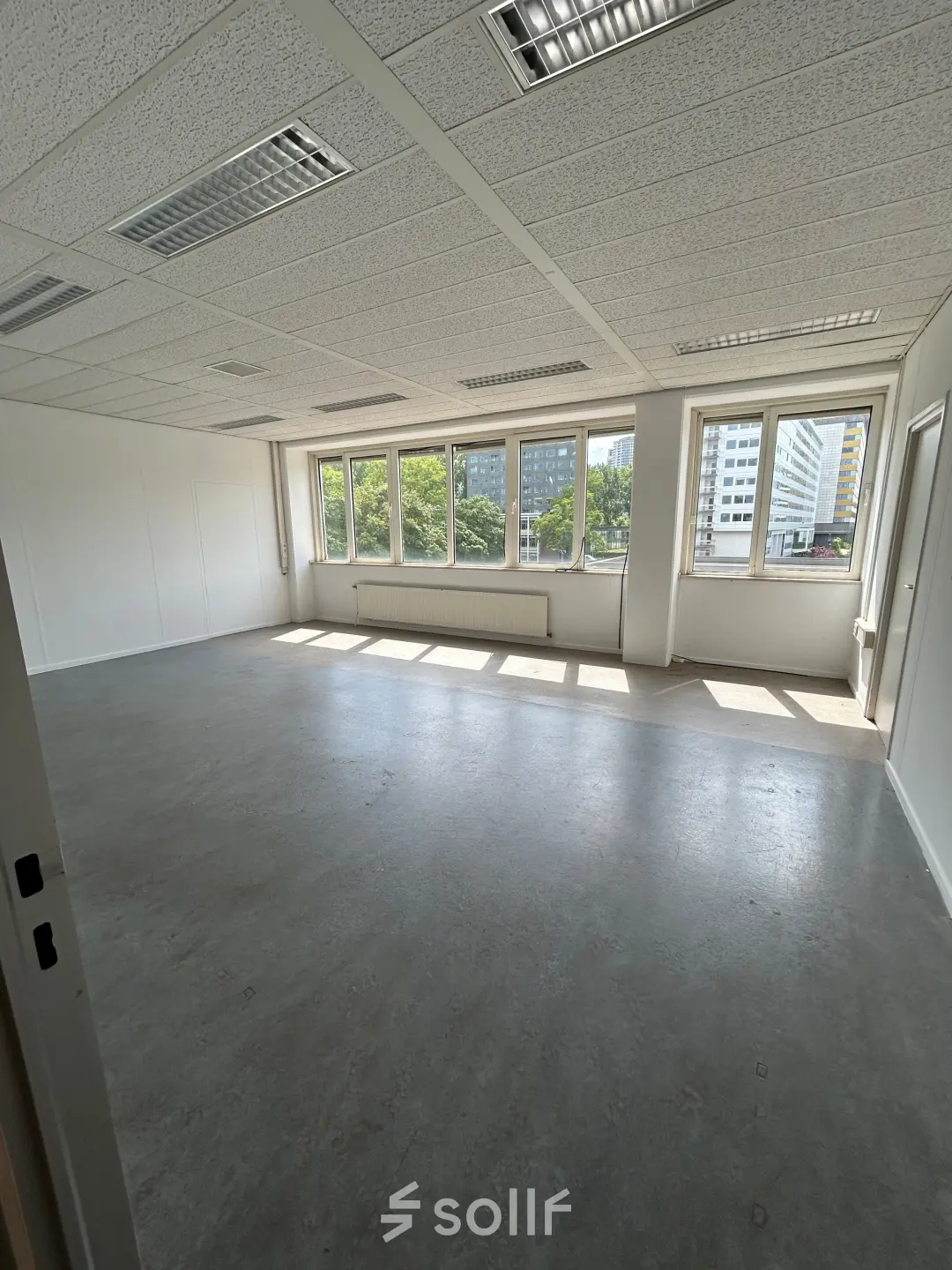 Bright office space available for rent at James Wattstraat 71, Amsterdam East, featuring large windows and ample natural light.