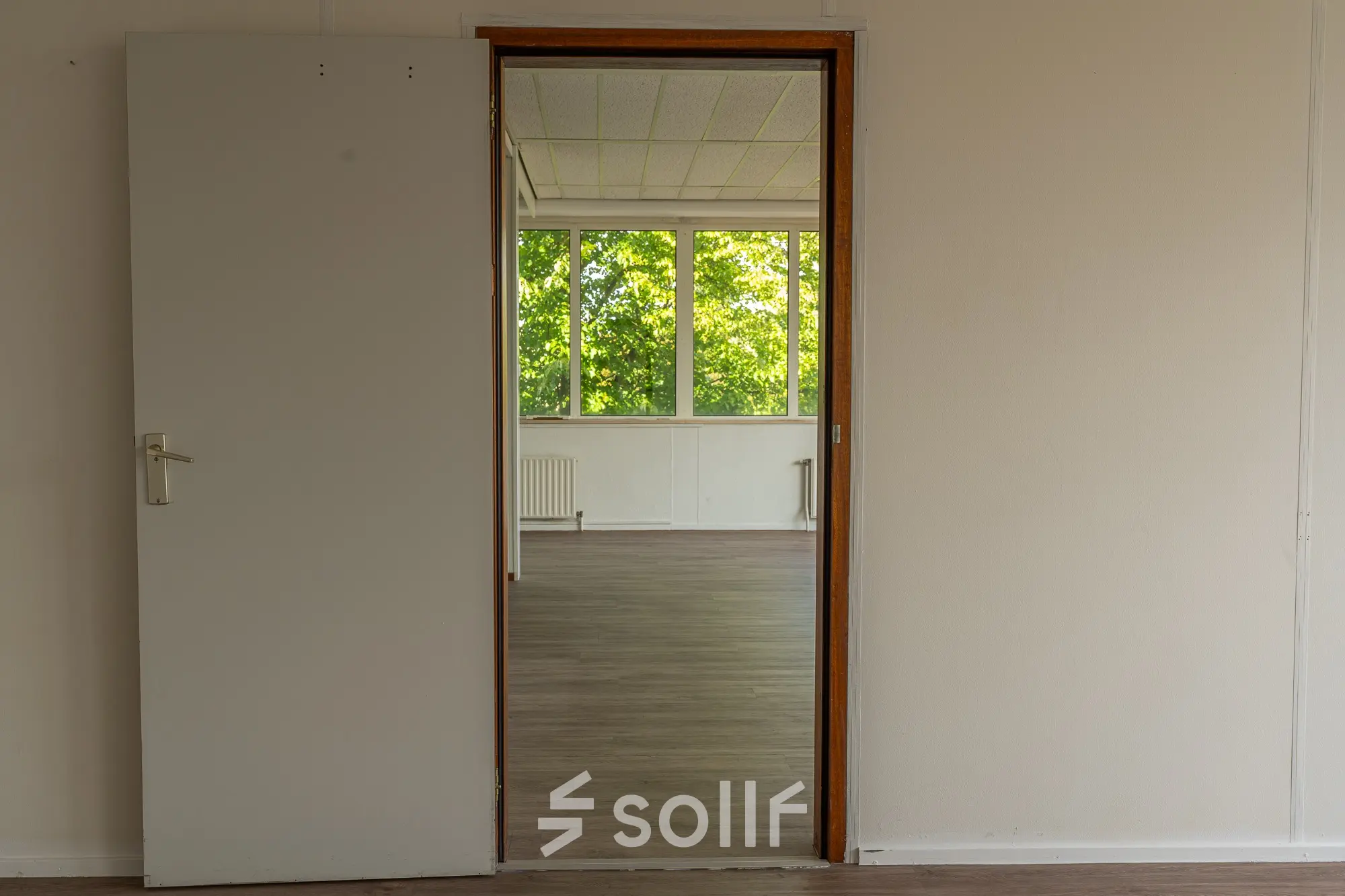 Unfurnished office space with wooden flooring and large windows at James Wattstraat 71, ideal for rent office space in Amsterdam East.
