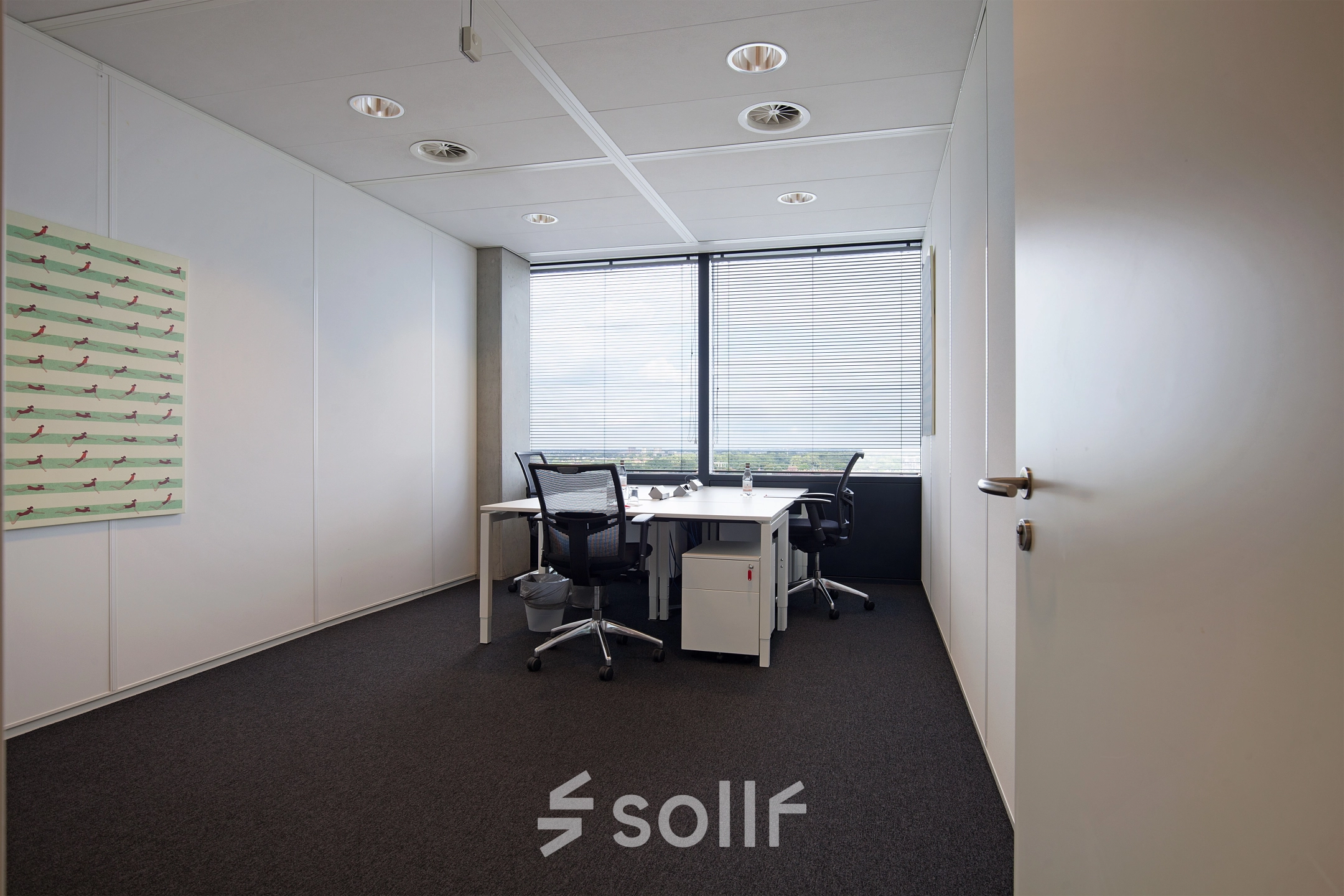 Office space with desks and chairs overlooking a cityscape at Piet Heinkade 55, ideal for those seeking office space rental in Amsterdam East.