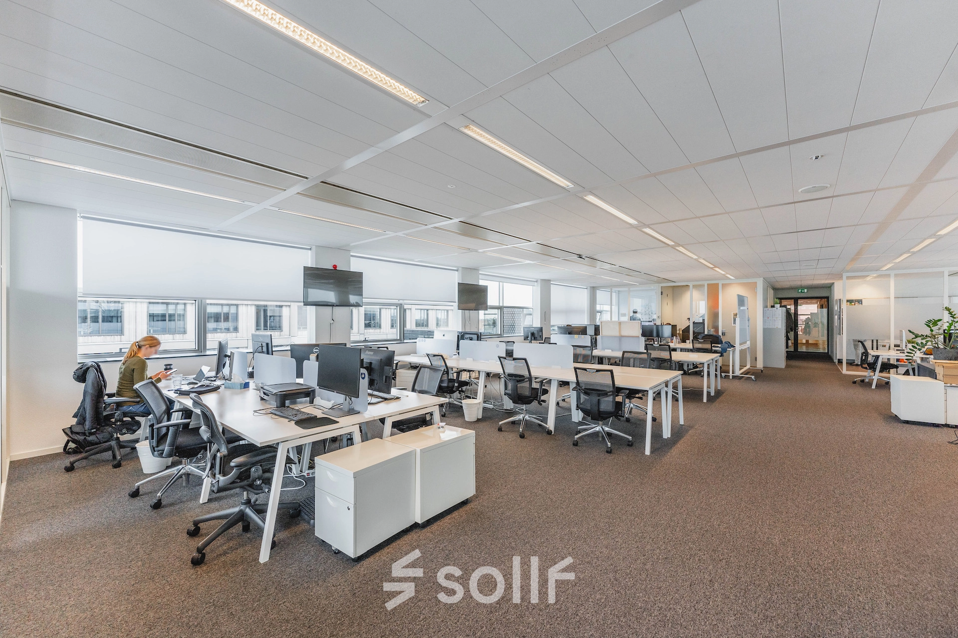 Bright, modern office space at Piet Heinkade 95B in Amsterdam East, featuring rows of desks and large windows, ideal for office space rental.