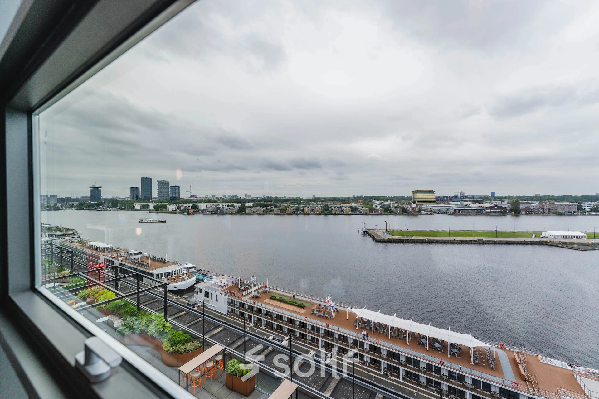 View of the waterfront and skyline from the office at Piet Heinkade 95B, ideal for those seeking office space rental in Amsterdam East.
