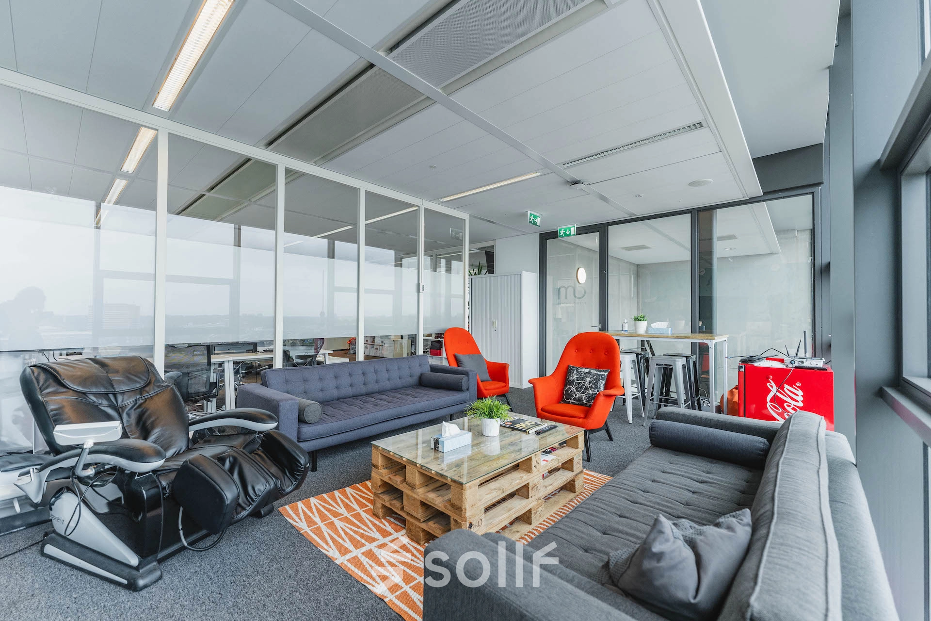 Bright office space featuring modern furnishings with couches and chairs, ideal for office space rental in Amsterdam East at Piet Heinkade 95B.