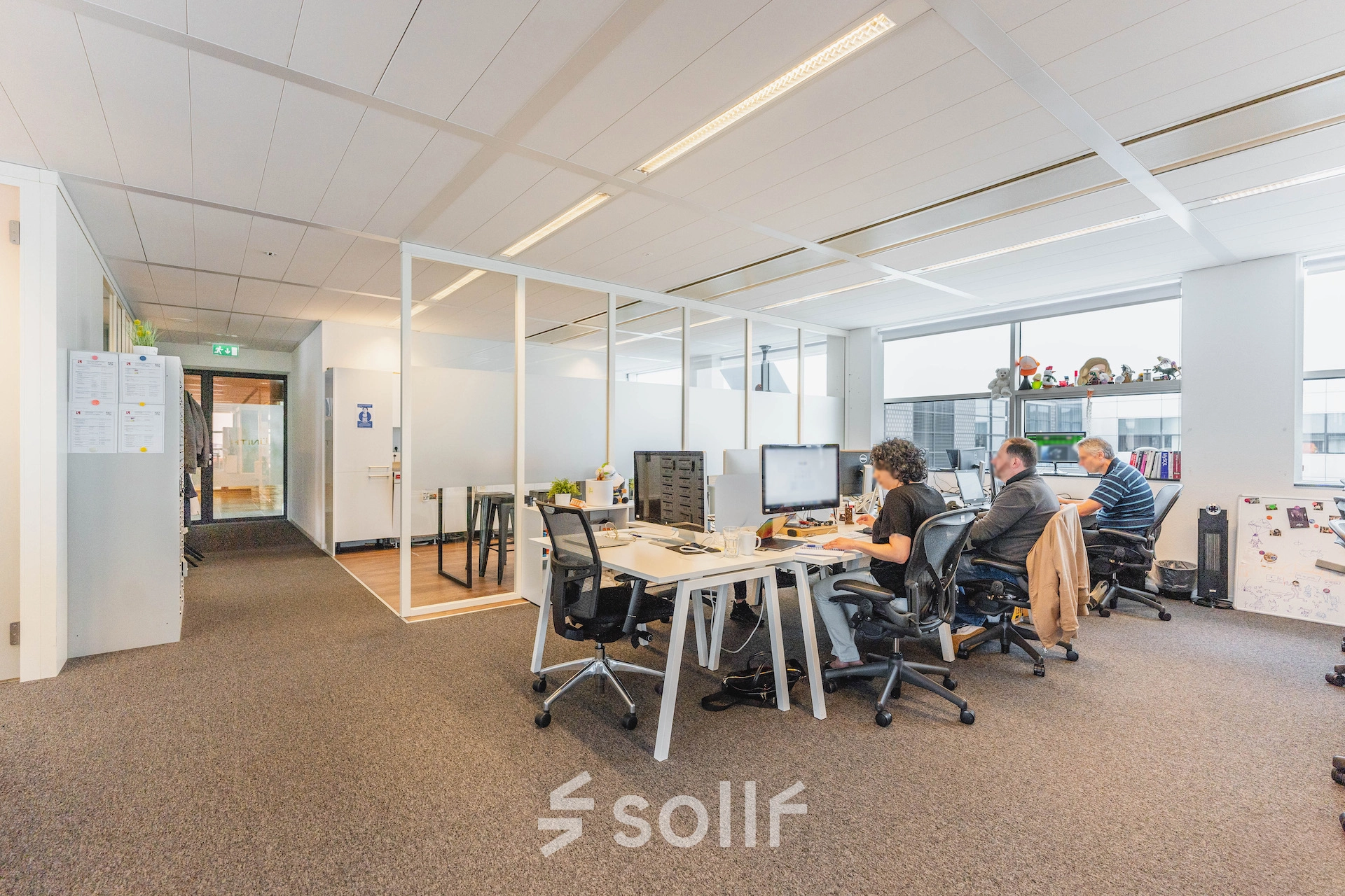 Office to rent at Piet Heinkade 95B in Amsterdam East, featuring modern workspaces with professionals engaged in tasks at their desks.