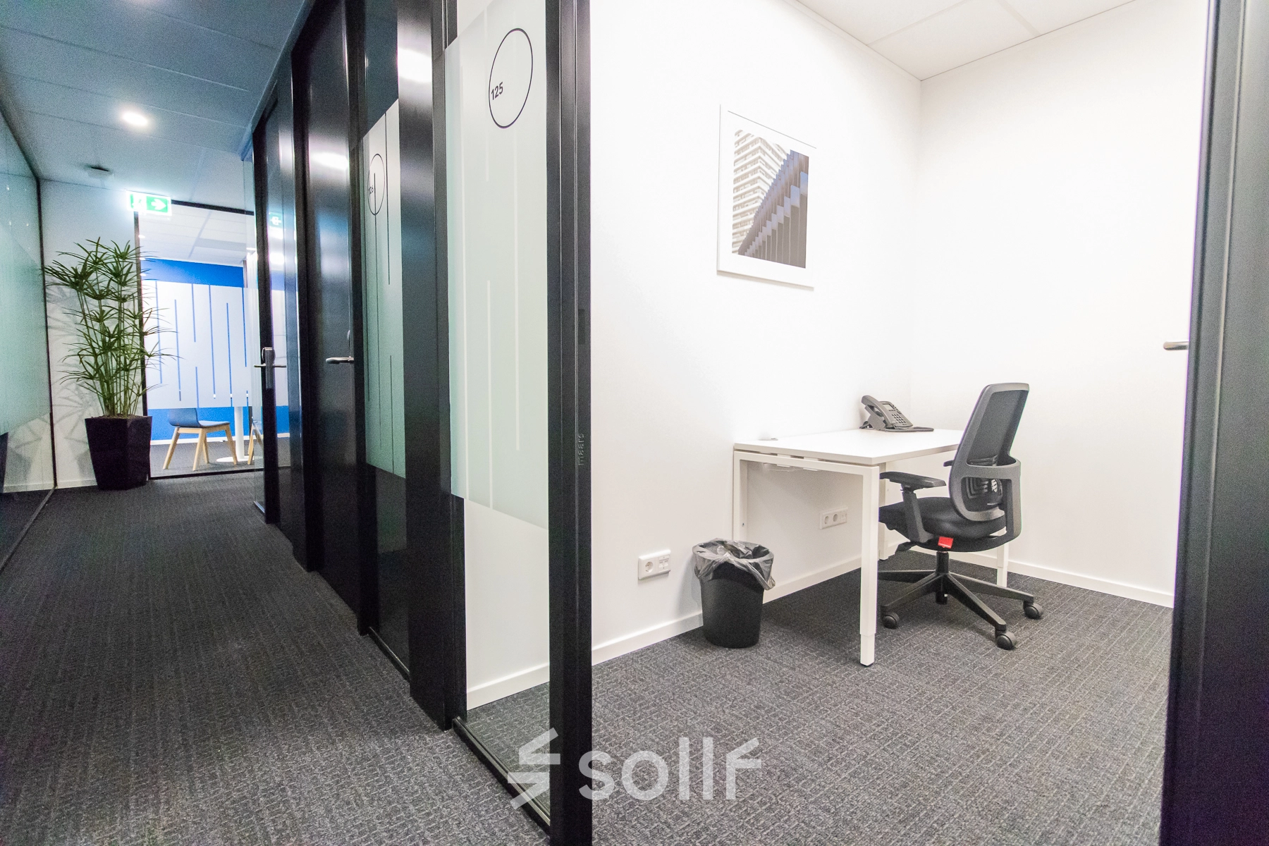 Modern office space with a desk, chair, and phone, located at Rhijnspoorplein 10-38, Amsterdam East. Suitable for those looking for office space rental.