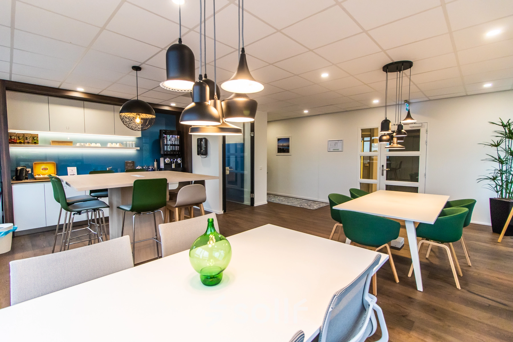 Modern office space at Rhijnspoorplein 10-38 in Amsterdam East with stylish furnishings, perfect for office space rental. Features sleek tables and contemporary lighting.