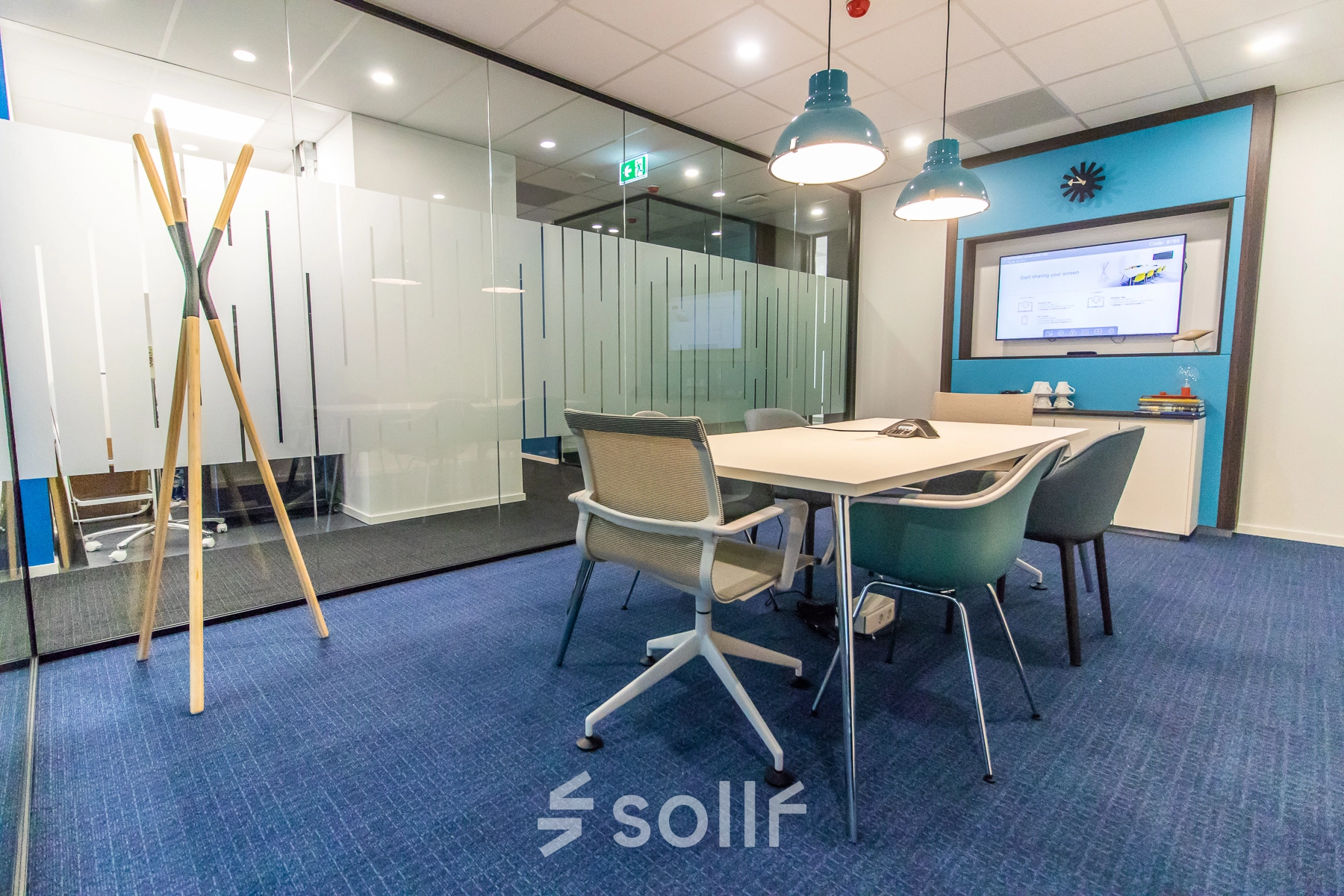 Modern conference room with a large table, ergonomic chairs, and glass partitions in an office available for rent at Rhijnspoorplein 10-38, Amsterdam East.