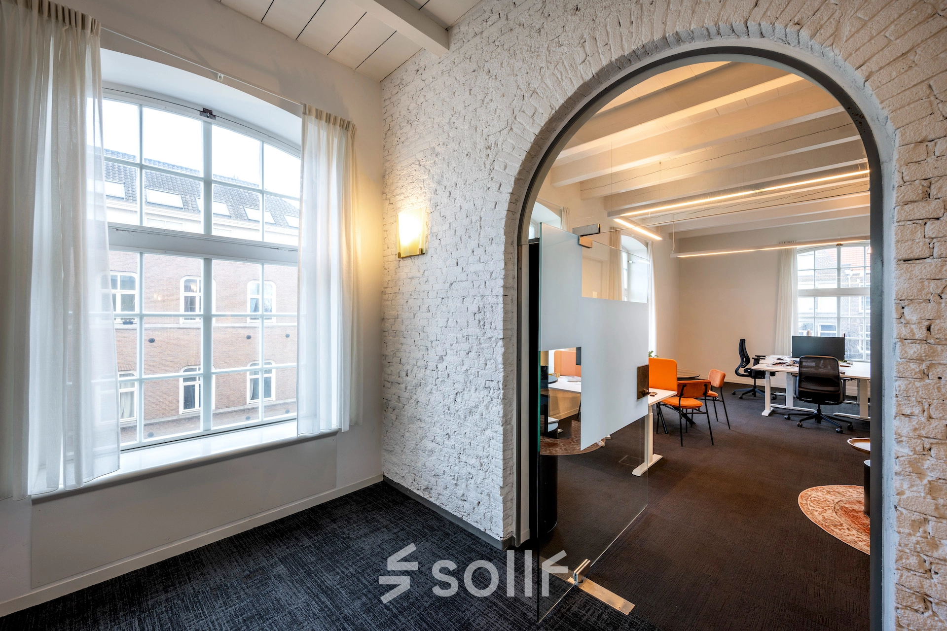 Bright office space for rent located at Sarphatistraat 370, Amsterdam East, featuring large windows and modern furnishings.