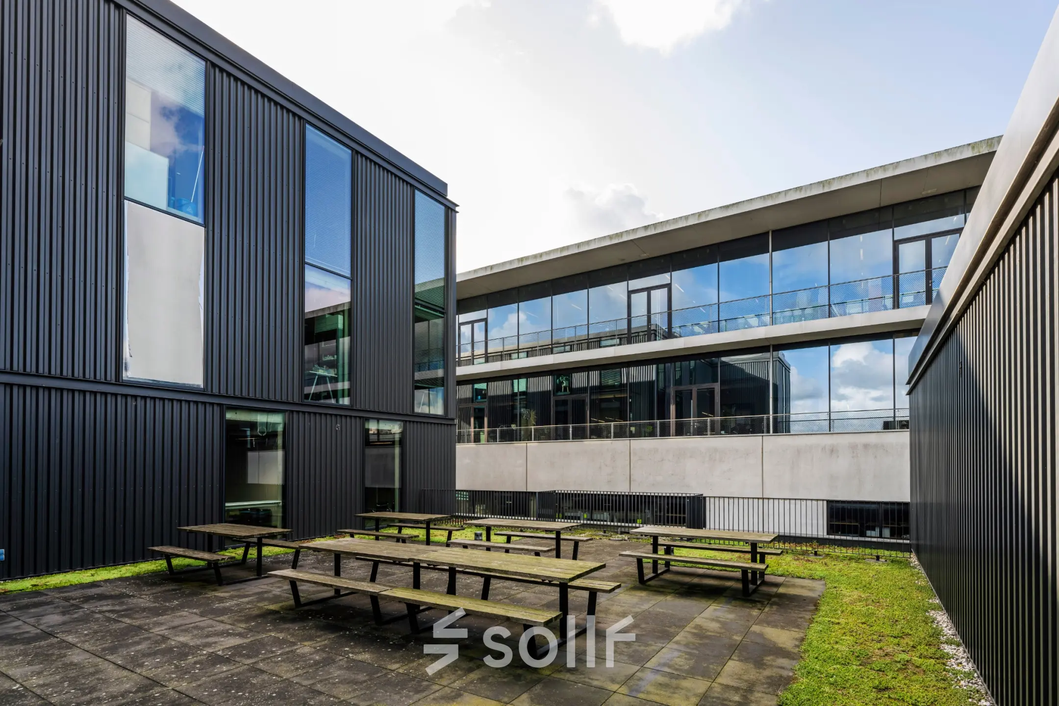 Modern office exterior with large windows and communal outdoor space at Moermanskkade 109-113, perfect for office space rental in Amsterdam Houthavens.