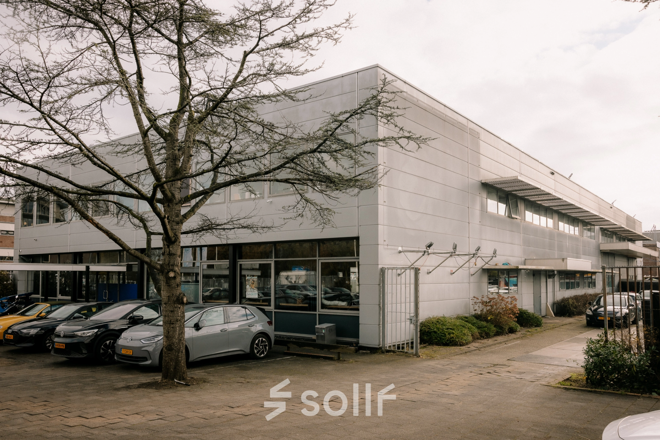 Exterior view of an office building available for rent at Anthony Fokkerweg 3, Amsterdam New-West, showing parking spaces in front.
