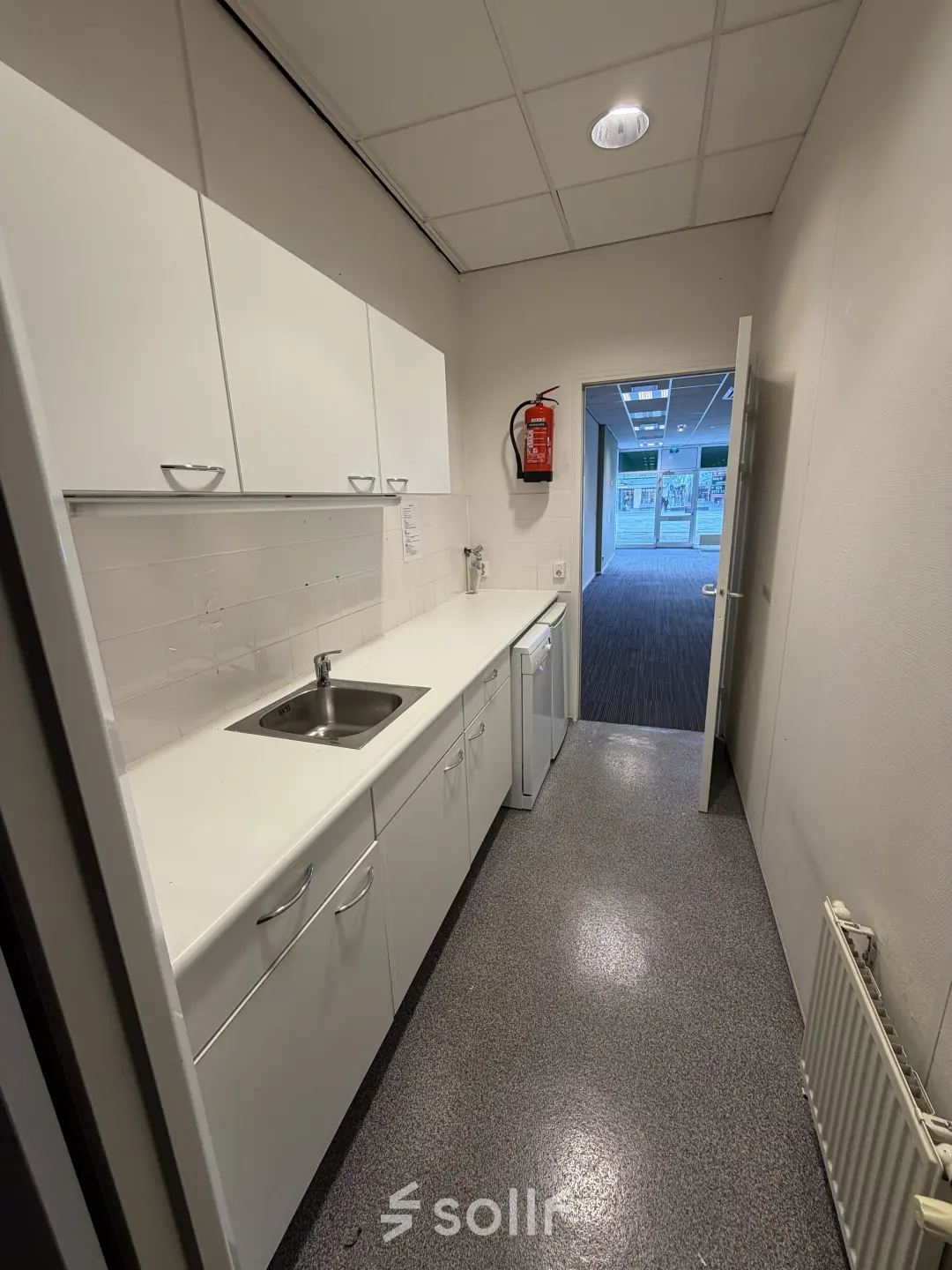 Compact office pantry with white cabinetry and sink, located at Buikslotermeerplein 430, Amsterdam North, perfect for small office space rental.