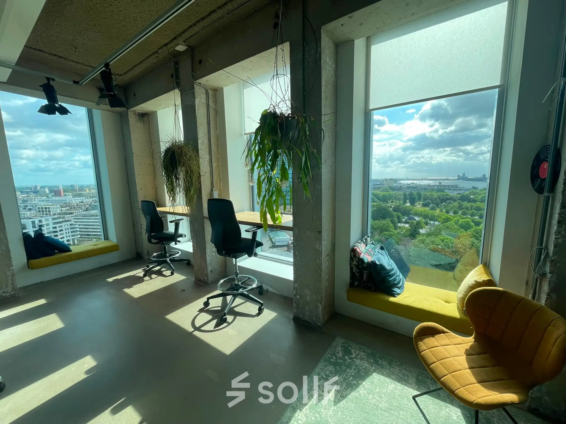 Bright office space at Overhoeksplein 1, Amsterdam North with large windows, offering a stunning view. Ideal for rent office space seekers. Furnished with chairs and a cozy seating area.