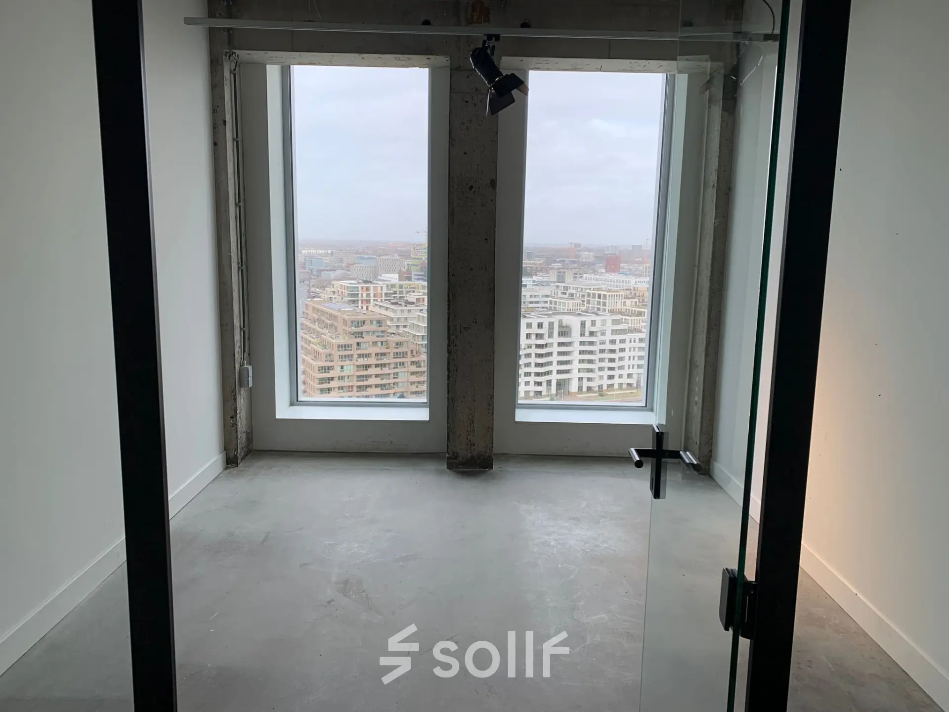 Unfurnished office space at Overhoeksplein 1, Amsterdam North, featuring large windows with city views. Ideal for those seeking open floorplan office space rental.