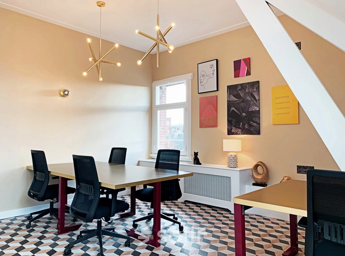 Bright office space rental with modern lighting, geometric flooring, and contemporary art on the walls, available in Amsterdam Old South at Emmalaan 7-9.