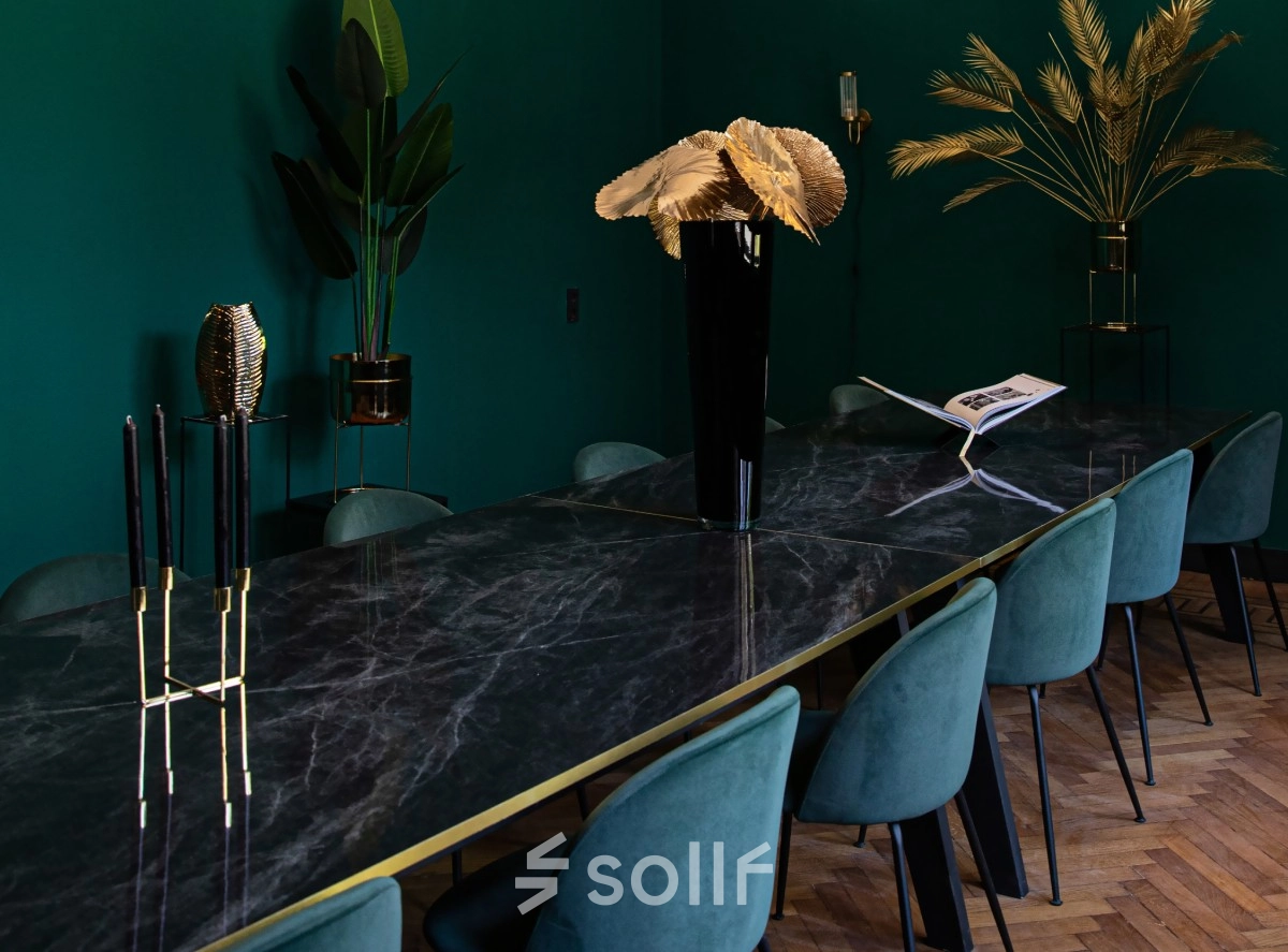 Furnished office space with a long marble table and teal chairs, located at Emmalaan 7-9. Ideal for office space rental in Amsterdam Old South.