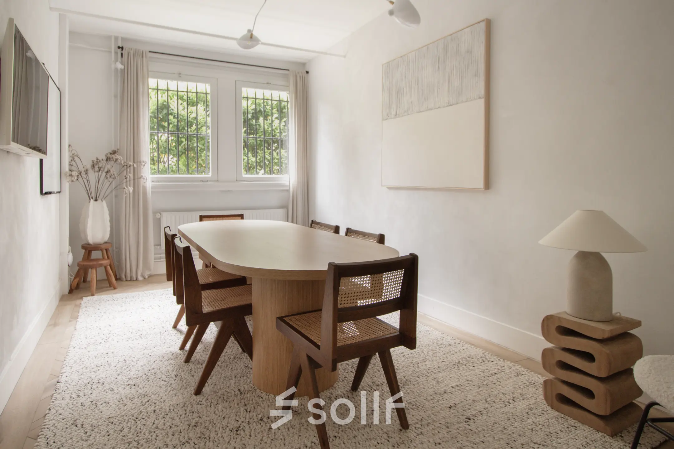 Bright office to rent in Amsterdam Old South, featuring a stylish table with chairs, modern lamp, and wall art, perfect for meetings or collaborative work.