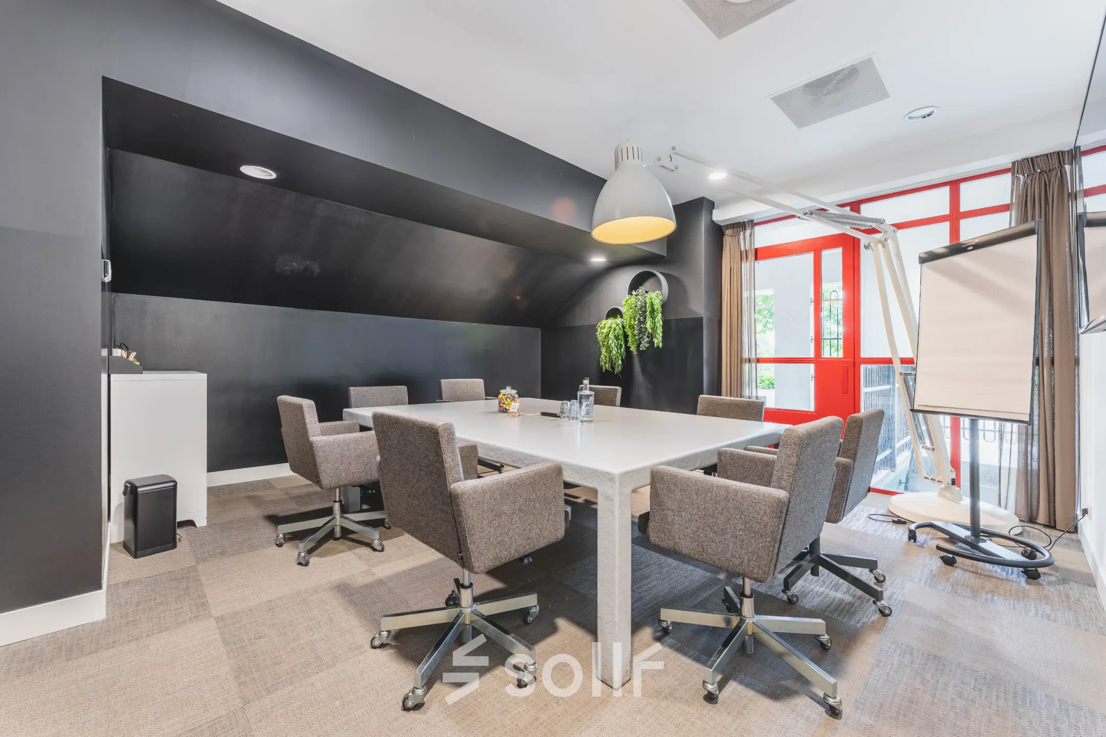 Modern office space rental in Amsterdam Old South featuring a conference room with a long table, ergonomic chairs, and bright natural lighting at Olympisch Stadion 24-28.