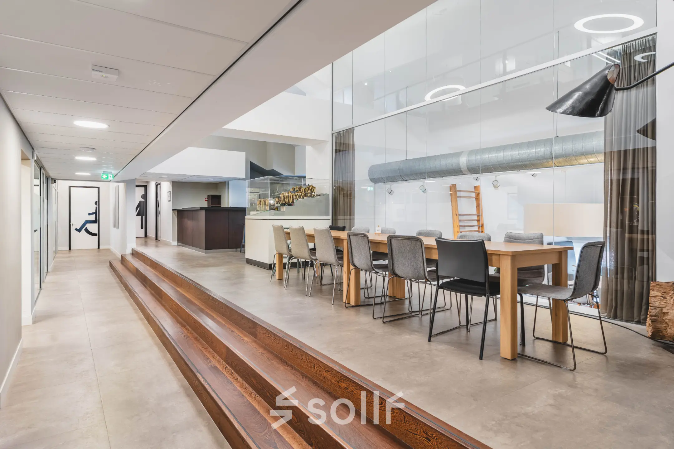 Spacious modern office with long meeting table and seating, featuring sleek design and ample lighting at Olympisch Stadion 24-28, perfect for office space rental in Amsterdam Old South.
