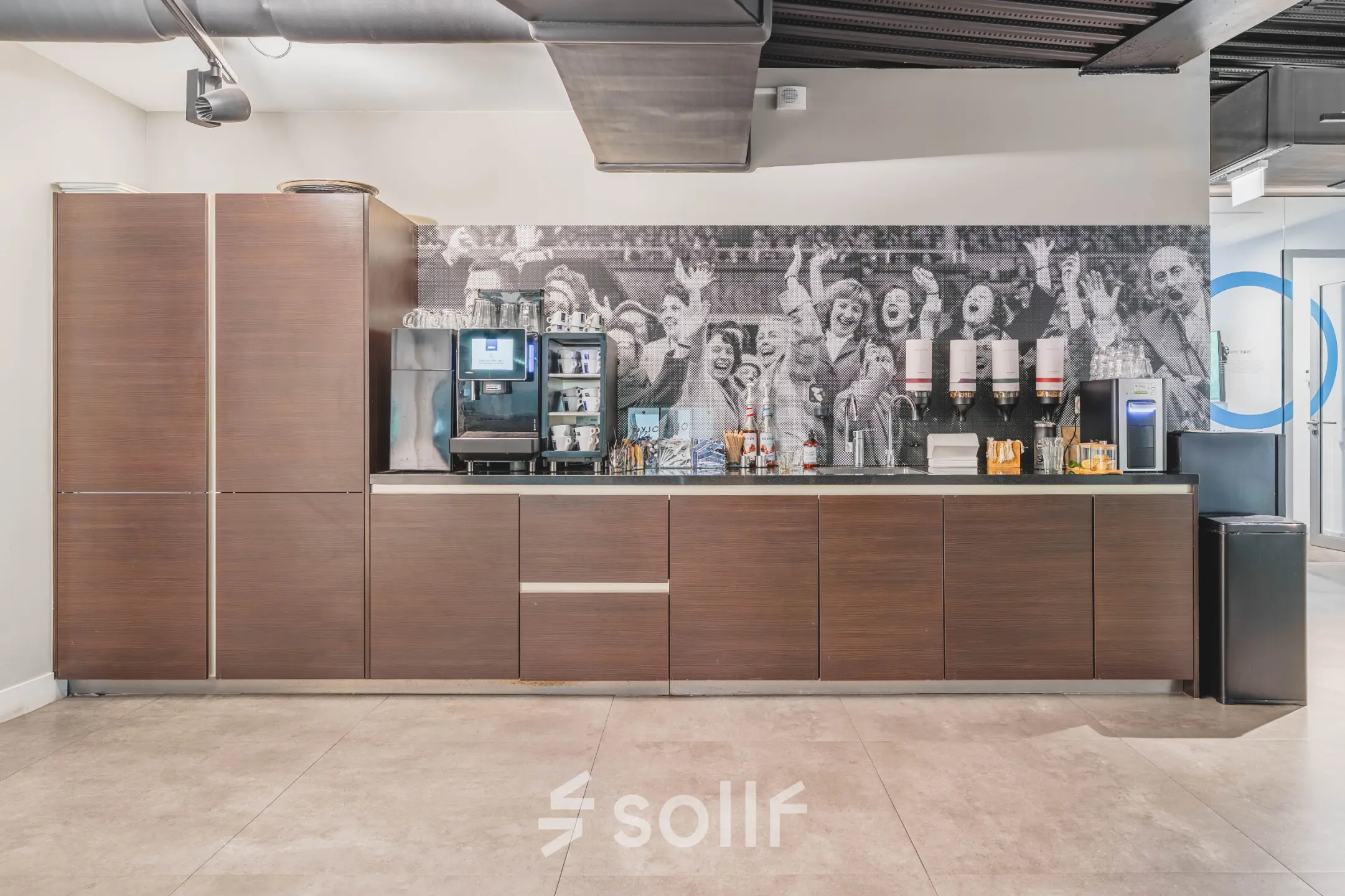 Office pantry at Olympisch Stadion 24-28 in Amsterdam Old South, featuring modern cabinetry, coffee machine, and beverage dispensers, ideal for your next office space rental.