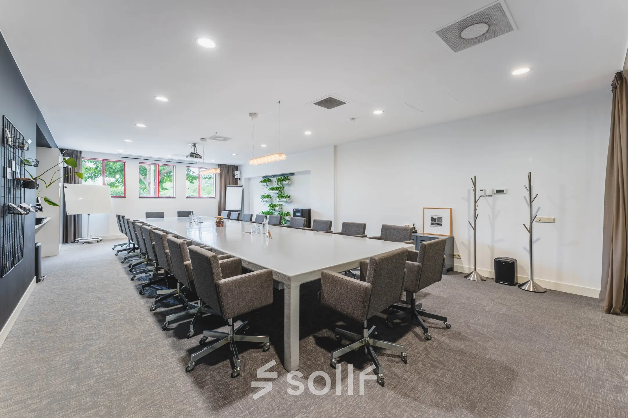 Spacious conference room with a long table and chairs in an office space available for rent at Olympisch Stadion 24-28, Amsterdam Old South.